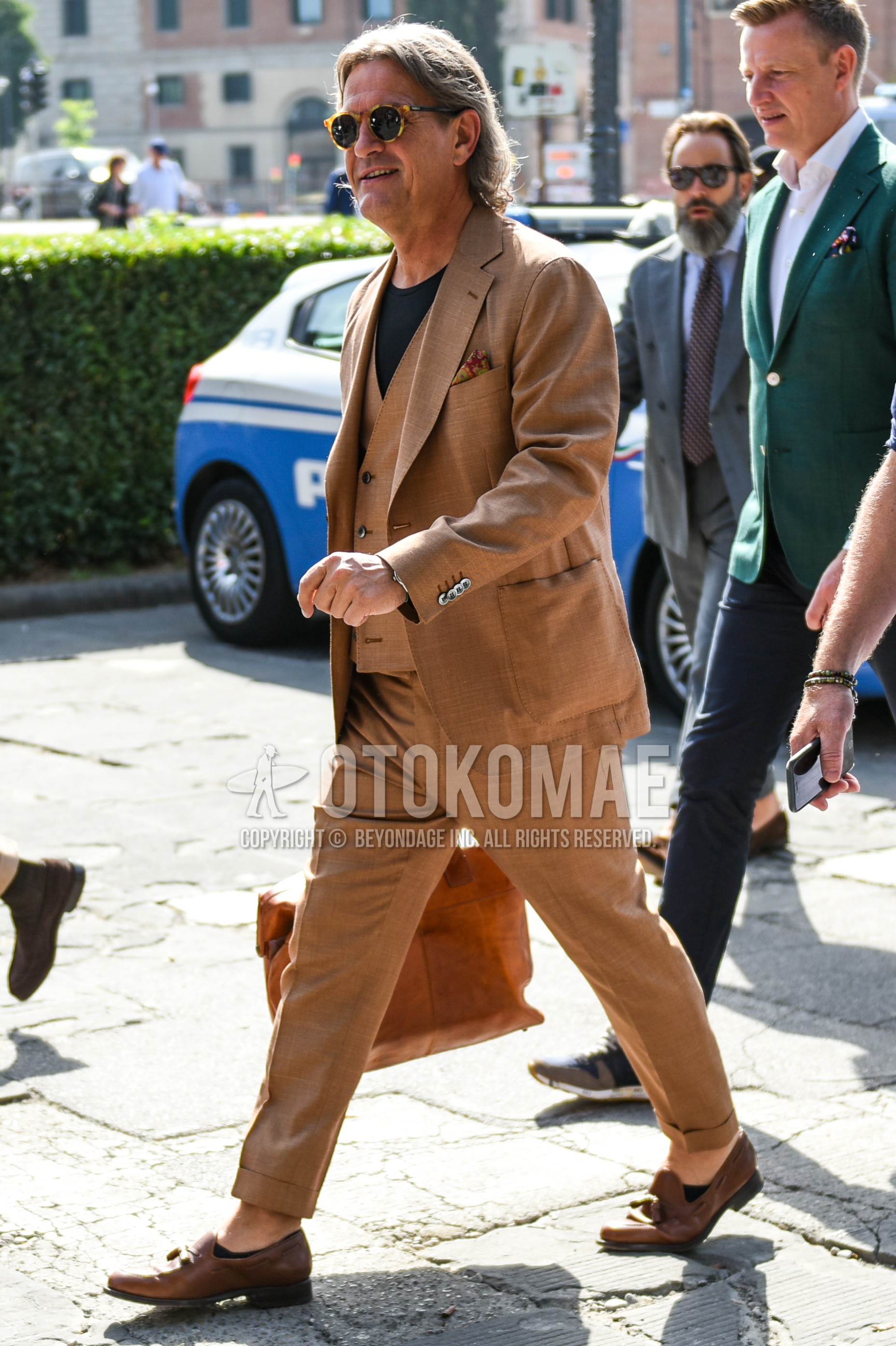 Men's spring autumn outfit with brown tortoiseshell sunglasses, black plain t-shirt, brown tassel loafers leather shoes, brown plain three-piece suit.