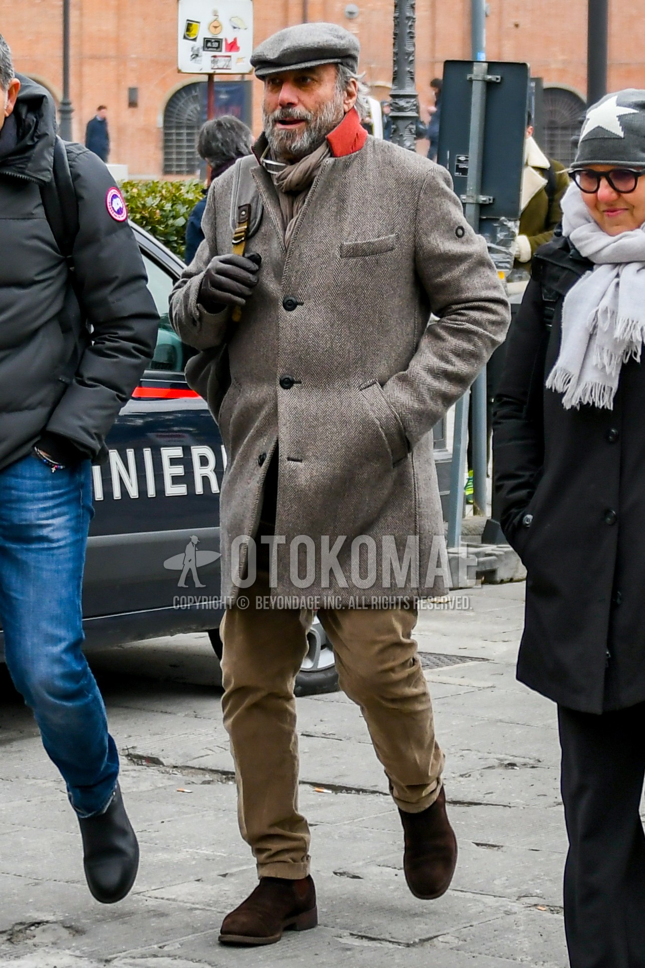 Men's autumn winter outfit with gray plain cap, beige plain scarf, beige herringbone chester coat, beige plain chinos, brown side-gore boots.