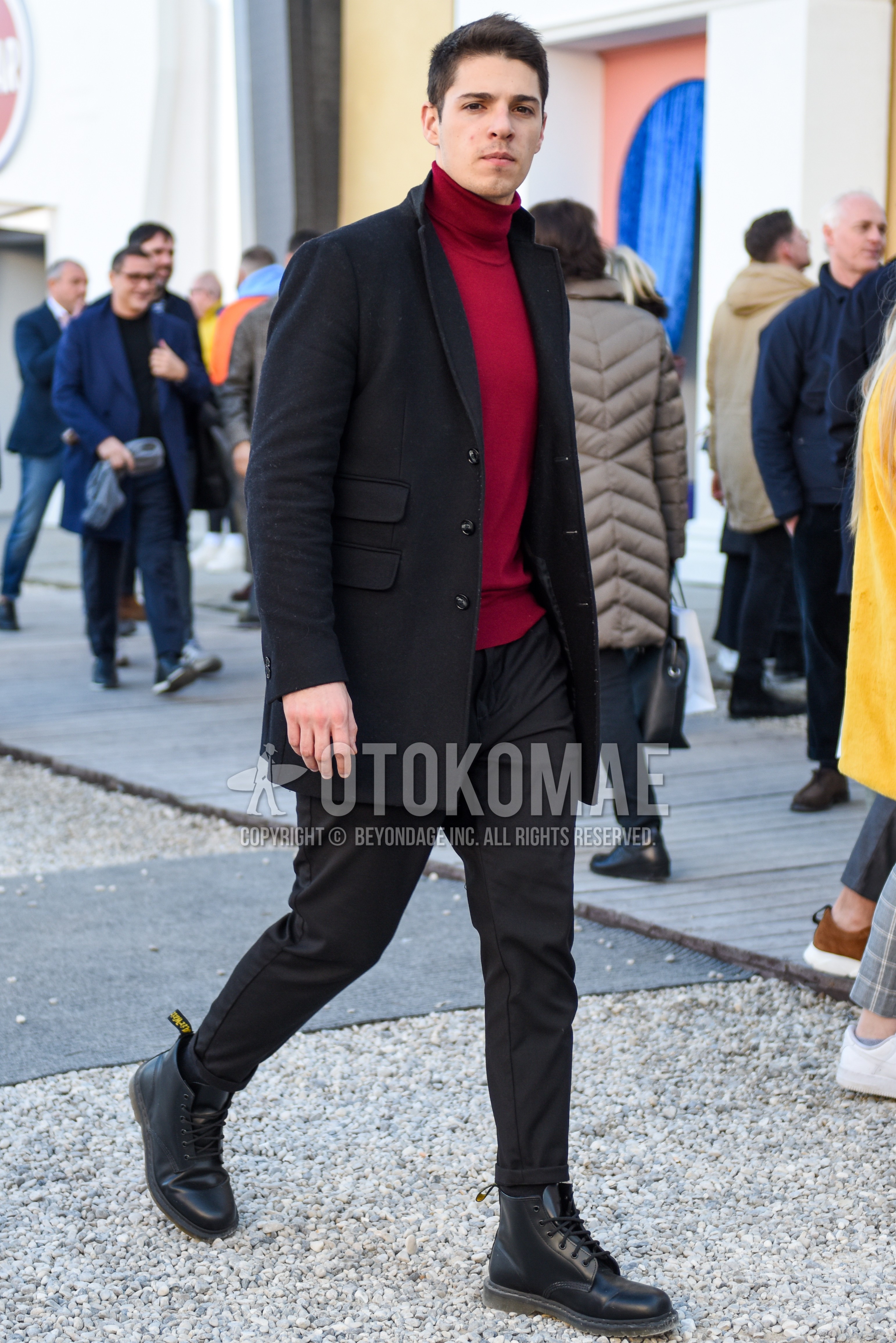 Men's autumn winter outfit with black plain chester coat, red plain turtleneck knit, gray plain slacks, dark gray plain socks, black work boots.