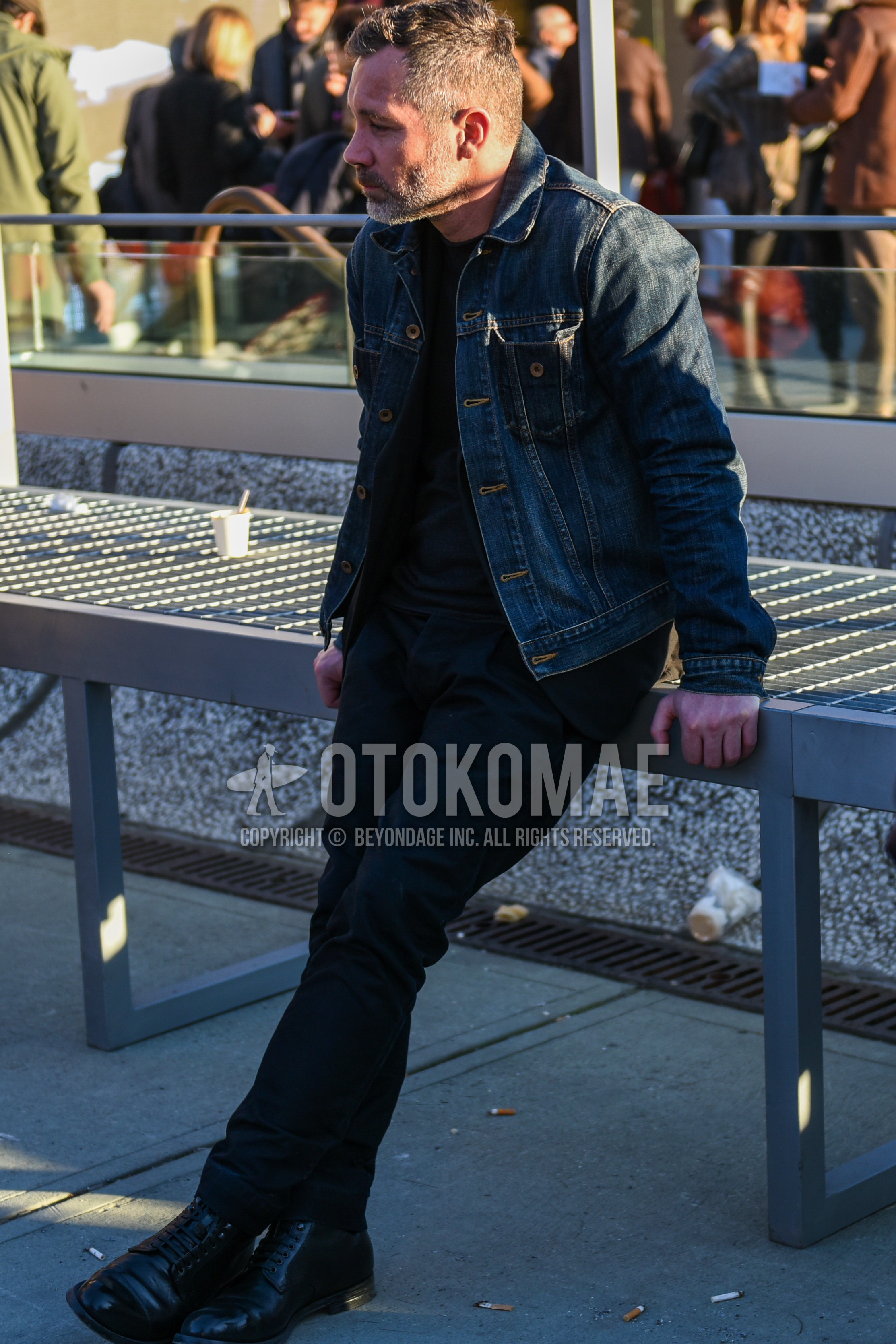 Men's spring autumn outfit with navy plain denim jacket, black plain sweater, black plain denim/jeans, black  boots.
