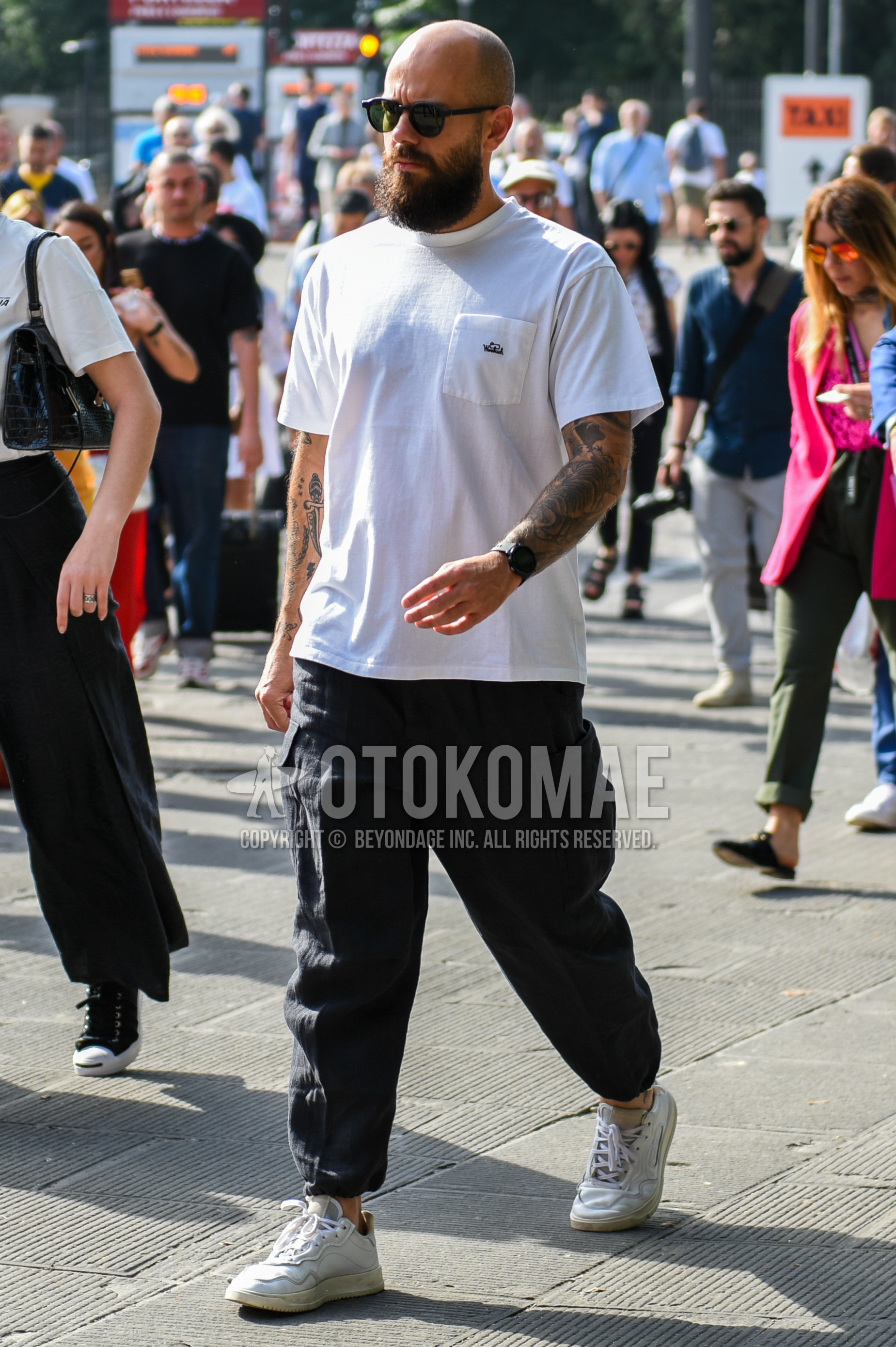 Men's summer outfit with plain sunglasses, white plain t-shirt, black plain cargo pants, white low-cut sneakers.