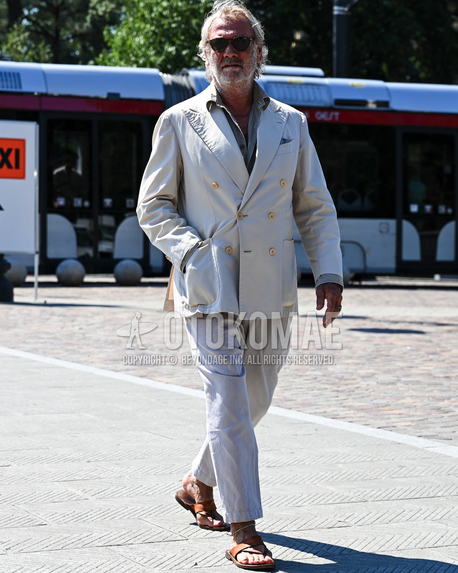 Men's spring summer autumn outfit with black plain sunglasses, gray plain shirt, brown leather sandals, white plain suit.