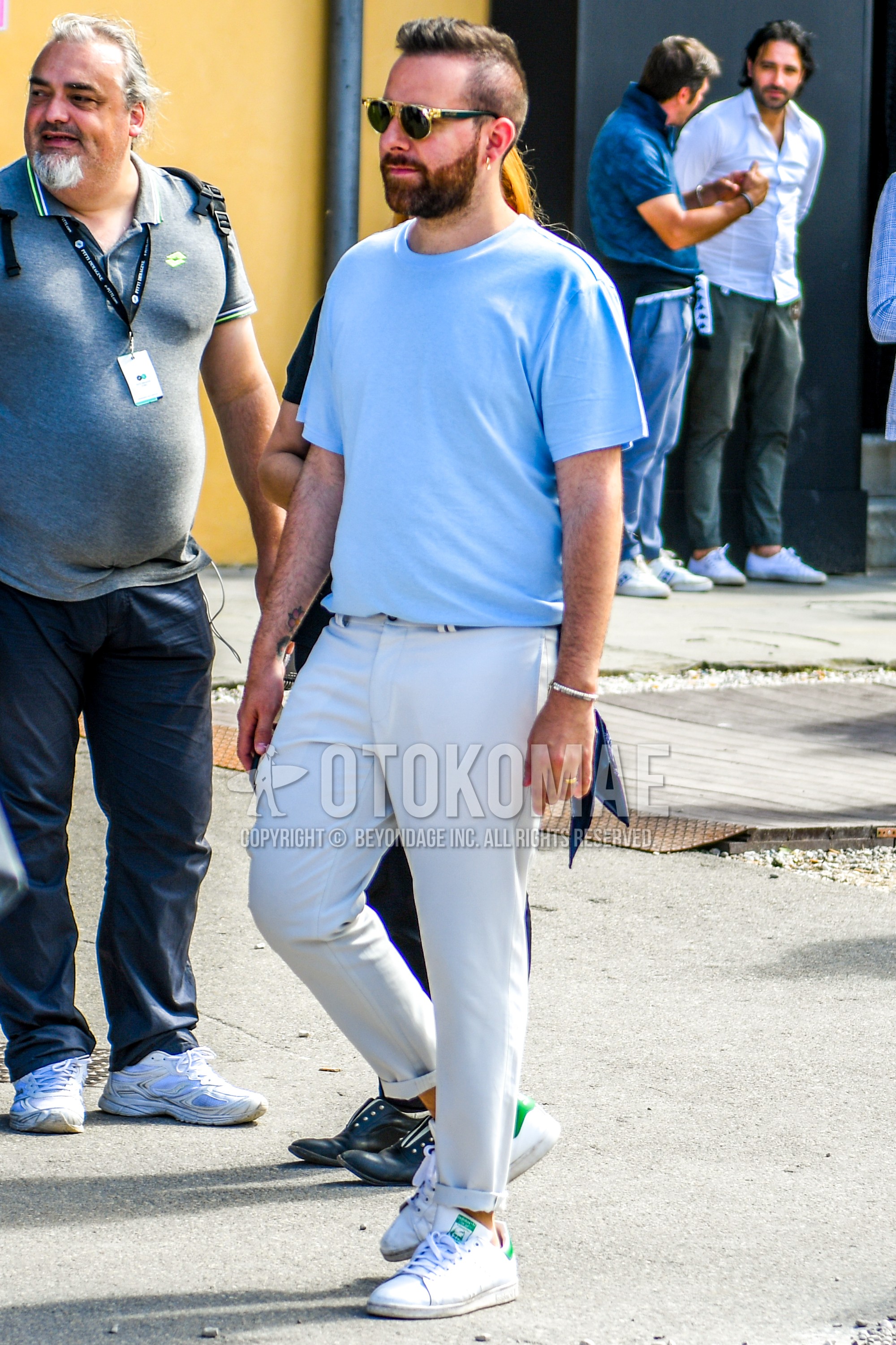 Men's summer outfit with plain sunglasses, light blue plain t-shirt, white plain cotton pants, white low-cut sneakers.