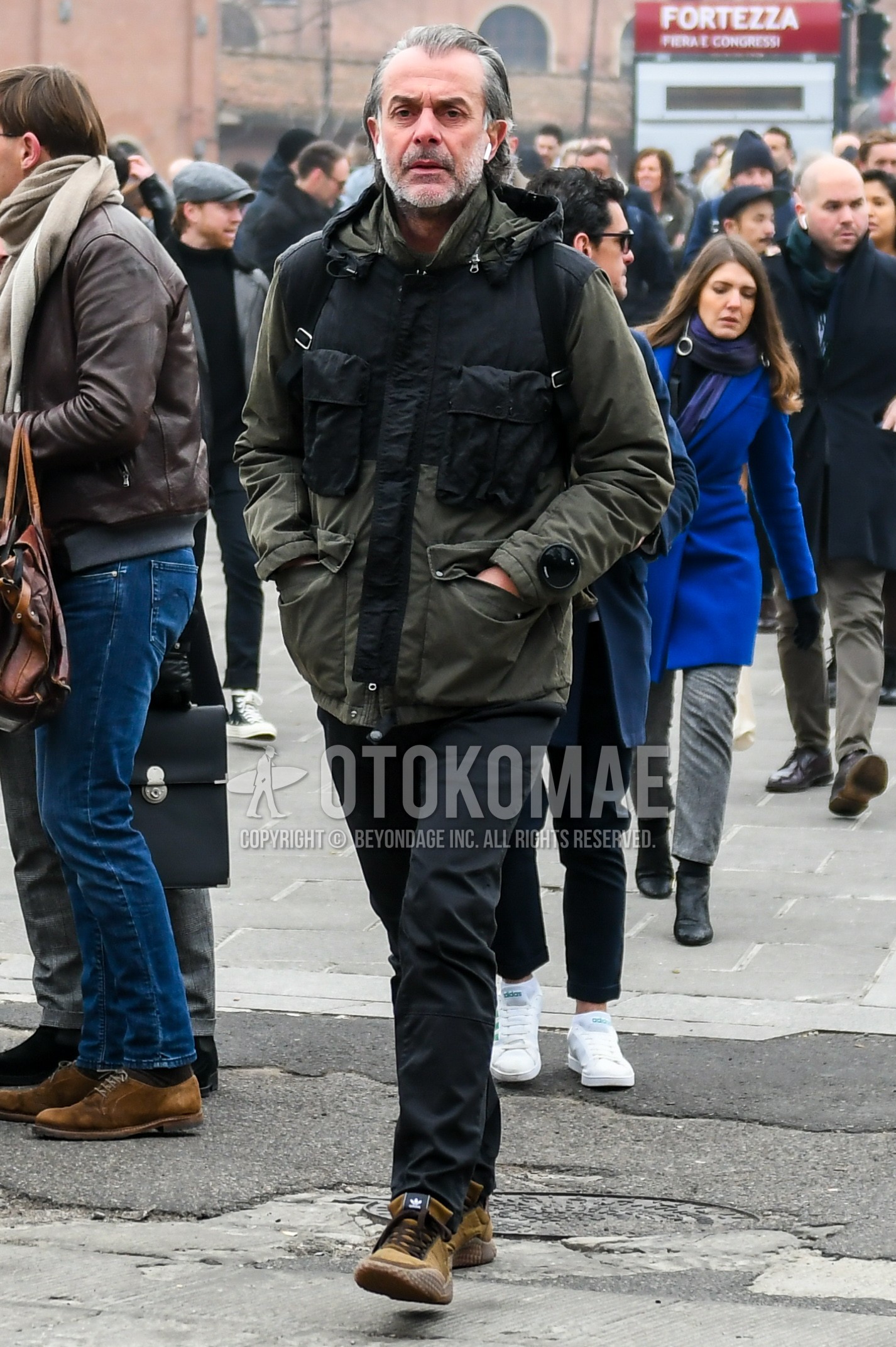 Men's winter outfit with olive green plain hooded coat, black plain cotton pants, brown low-cut sneakers.
