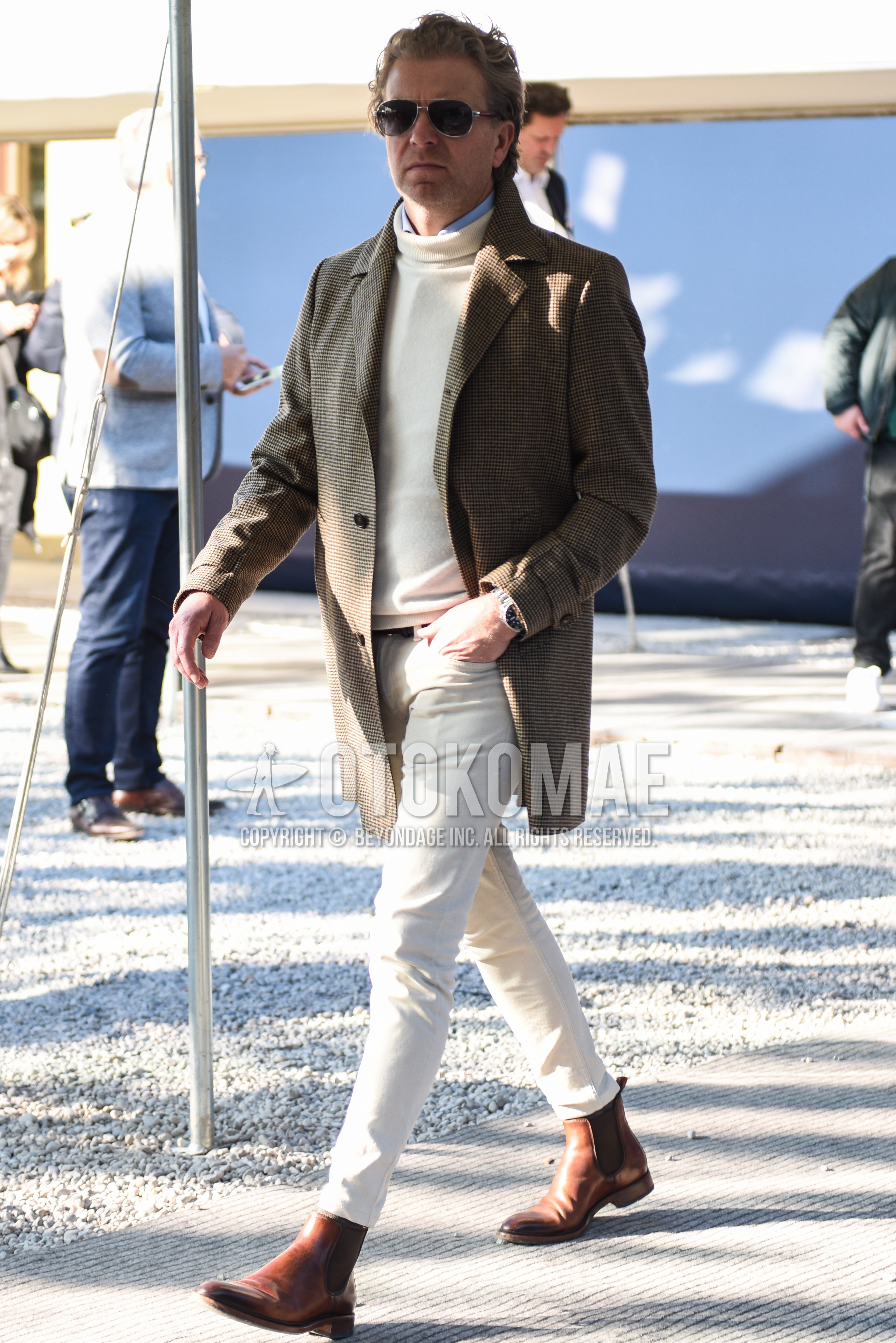 Men's autumn winter outfit with silver plain sunglasses, gray check chester coat, white plain turtleneck knit, light blue plain shirt, white plain cotton pants, white plain cropped pants, brown side-gore boots.