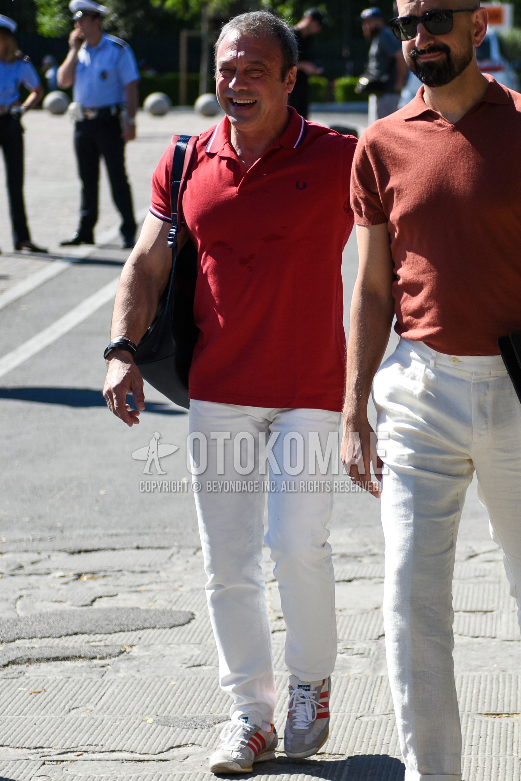 Men's summer outfit with red plain polo shirt, white plain cotton pants, gray red low-cut sneakers, black plain shoulder bag.