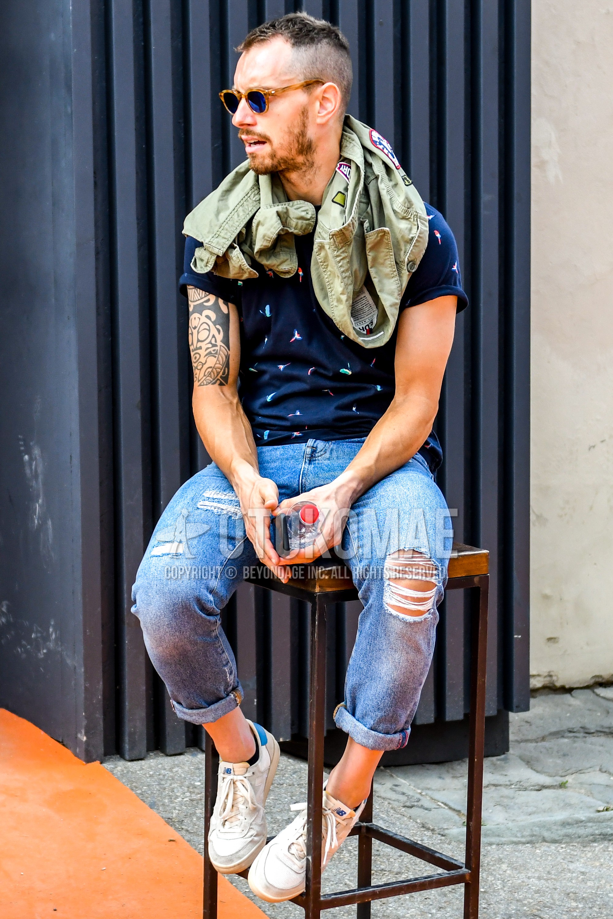 Men's summer outfit with tortoiseshell sunglasses, navy tops/innerwear t-shirt, blue plain denim/jeans, white low-cut sneakers.