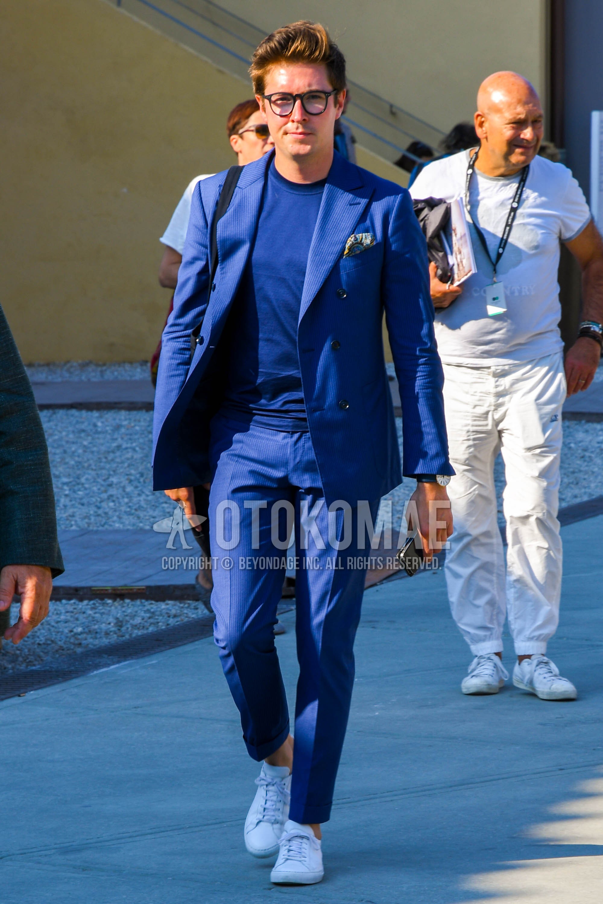Men's spring summer autumn outfit with plain glasses, blue plain t-shirt, white low-cut sneakers, blue plain suit.