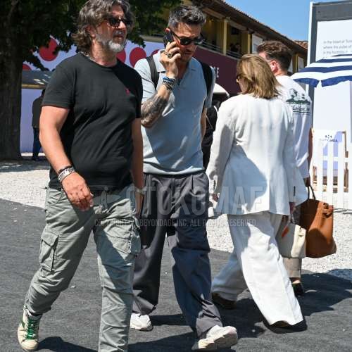 レイバン　ウェイファーラー　ウェリントンの黒無地のサングラス、ニットのグレー無地のポロシャツ、グレー無地のスラックス、グレー無地のプリーツパンツ、白ローカットのスニーカー、黒無地のバックパックを合わせた夏春のメンズコーデ・着こなし。