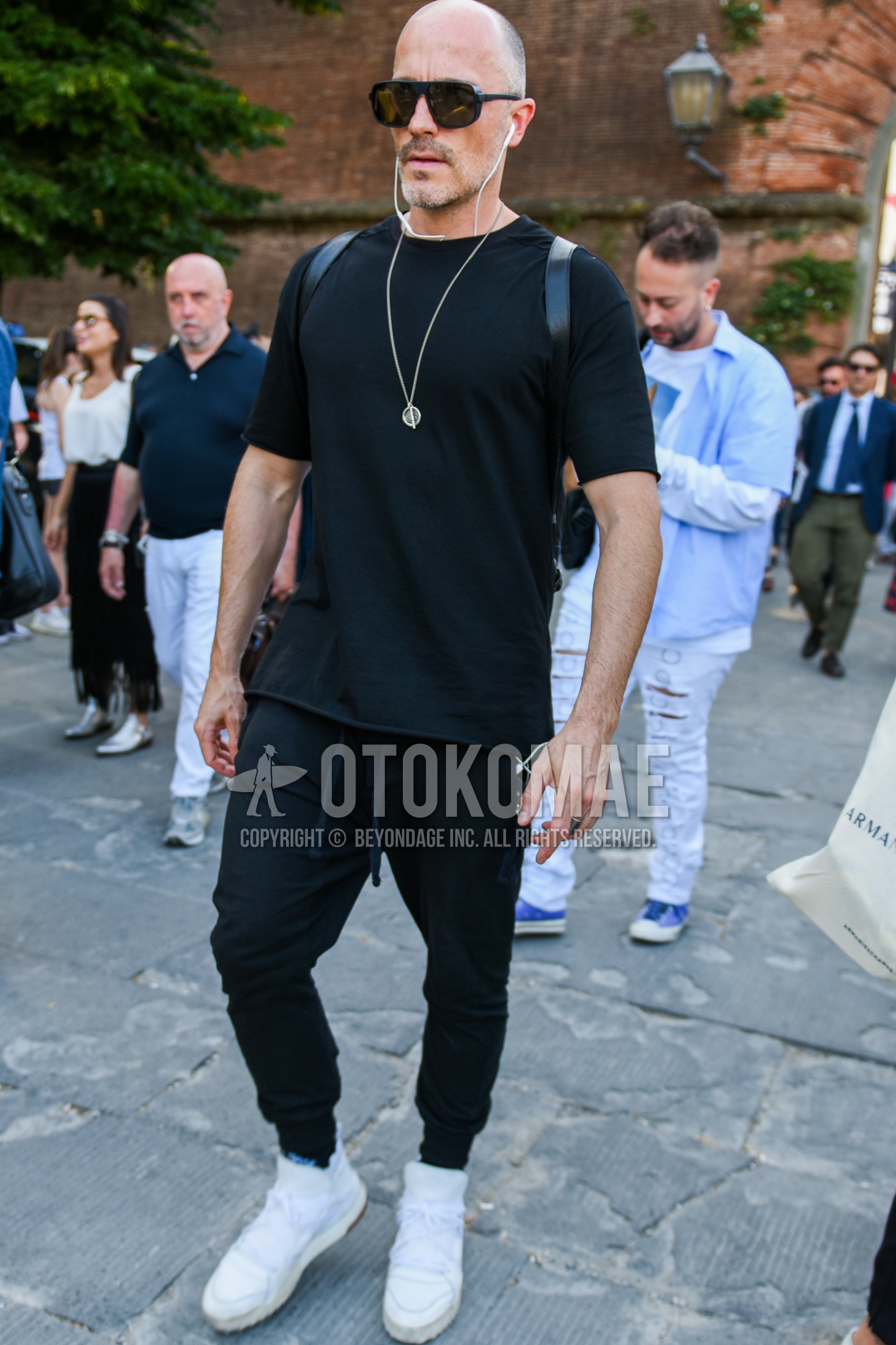 Men's summer outfit with black plain sunglasses, black plain t-shirt, black plain easy pants, plain jogger pants/ribbed pants, white high-cut sneakers.