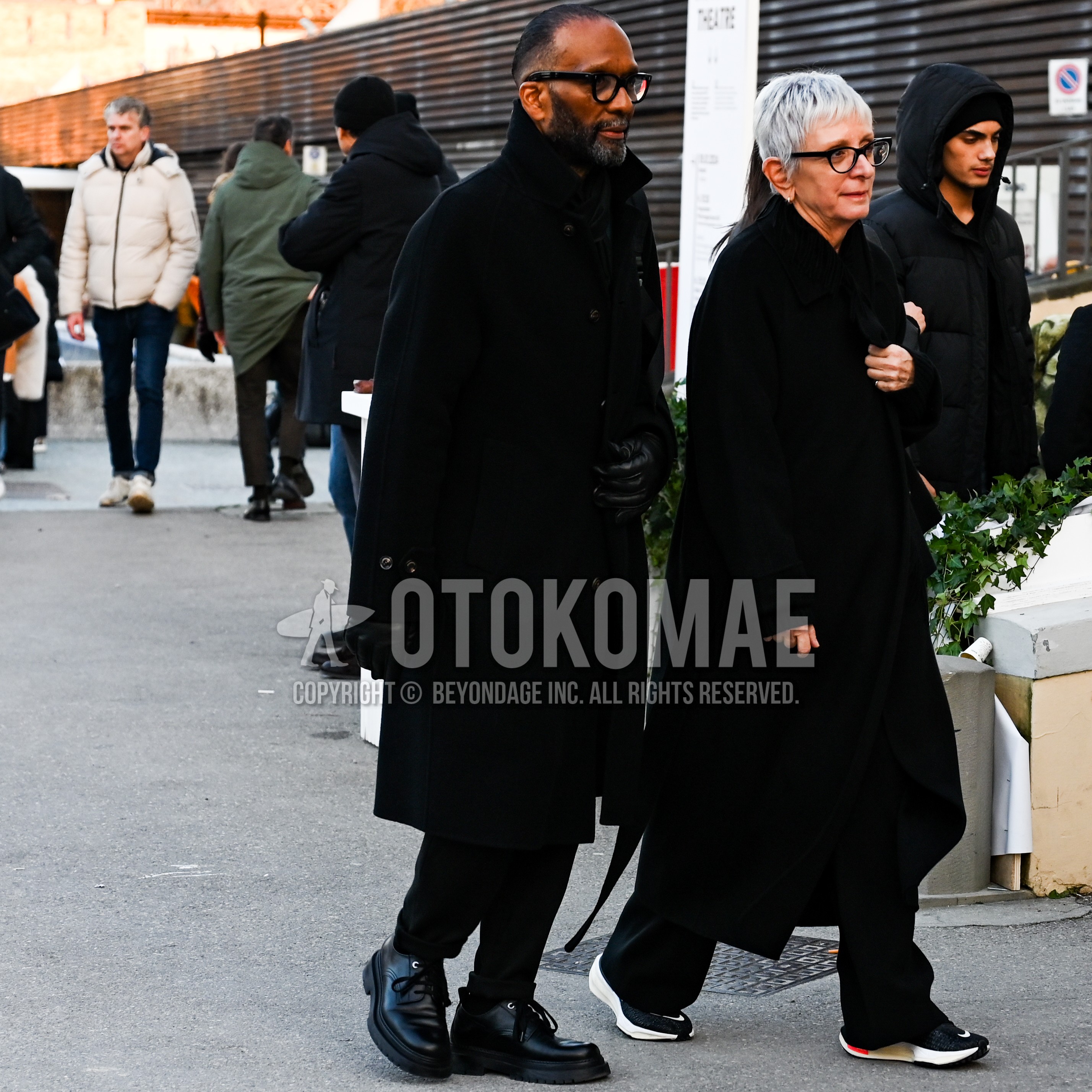 Men's autumn winter outfit with black plain glasses, black plain stand collar coat, black plain bottoms, black  loafers leather shoes.