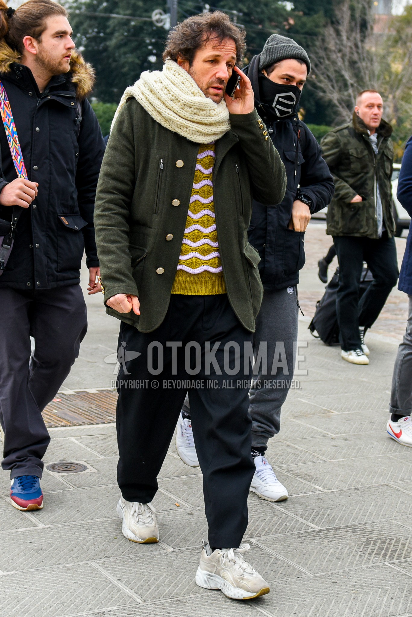Men's winter outfit with white plain scarf, yellow tops/innerwear sweater, black plain wide pants, white low-cut sneakers.