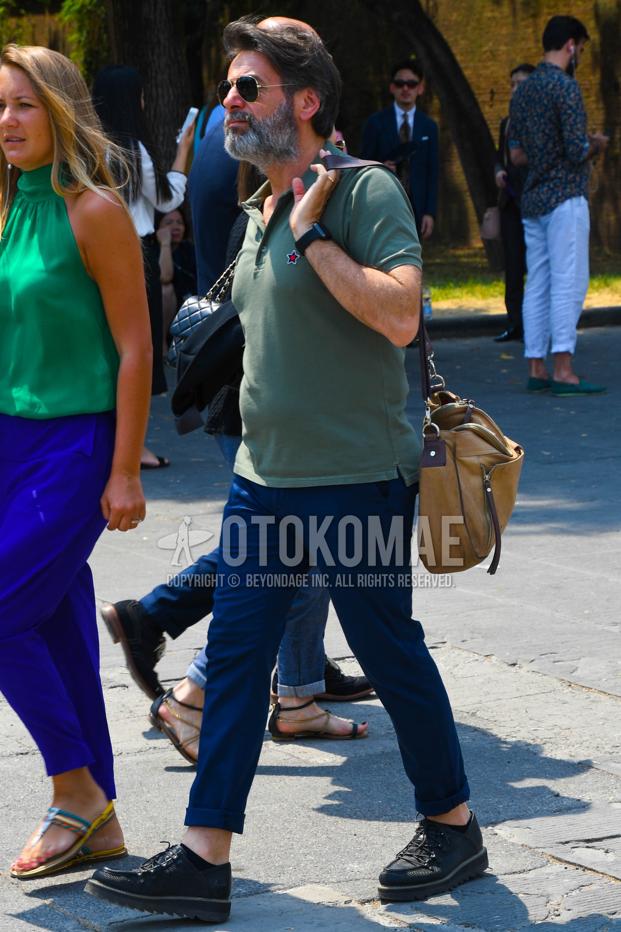 Men's summer outfit with plain sunglasses, olive green plain polo shirt, blue plain cotton pants, black leather shoes.