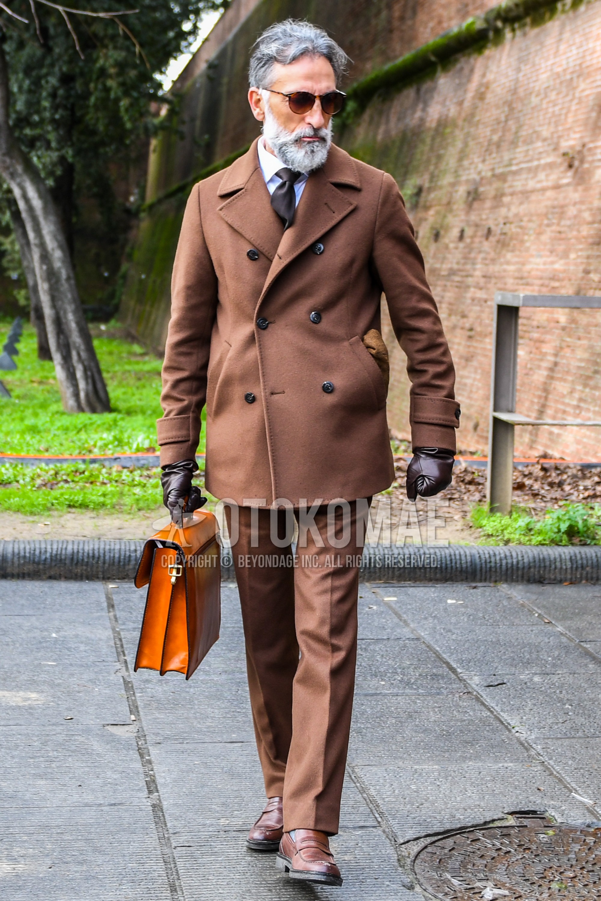 Men's winter outfit with plain sunglasses, brown plain p coat, white plain shirt, brown plain slacks, brown coin loafers leather shoes, orange plain briefcase/handbag.