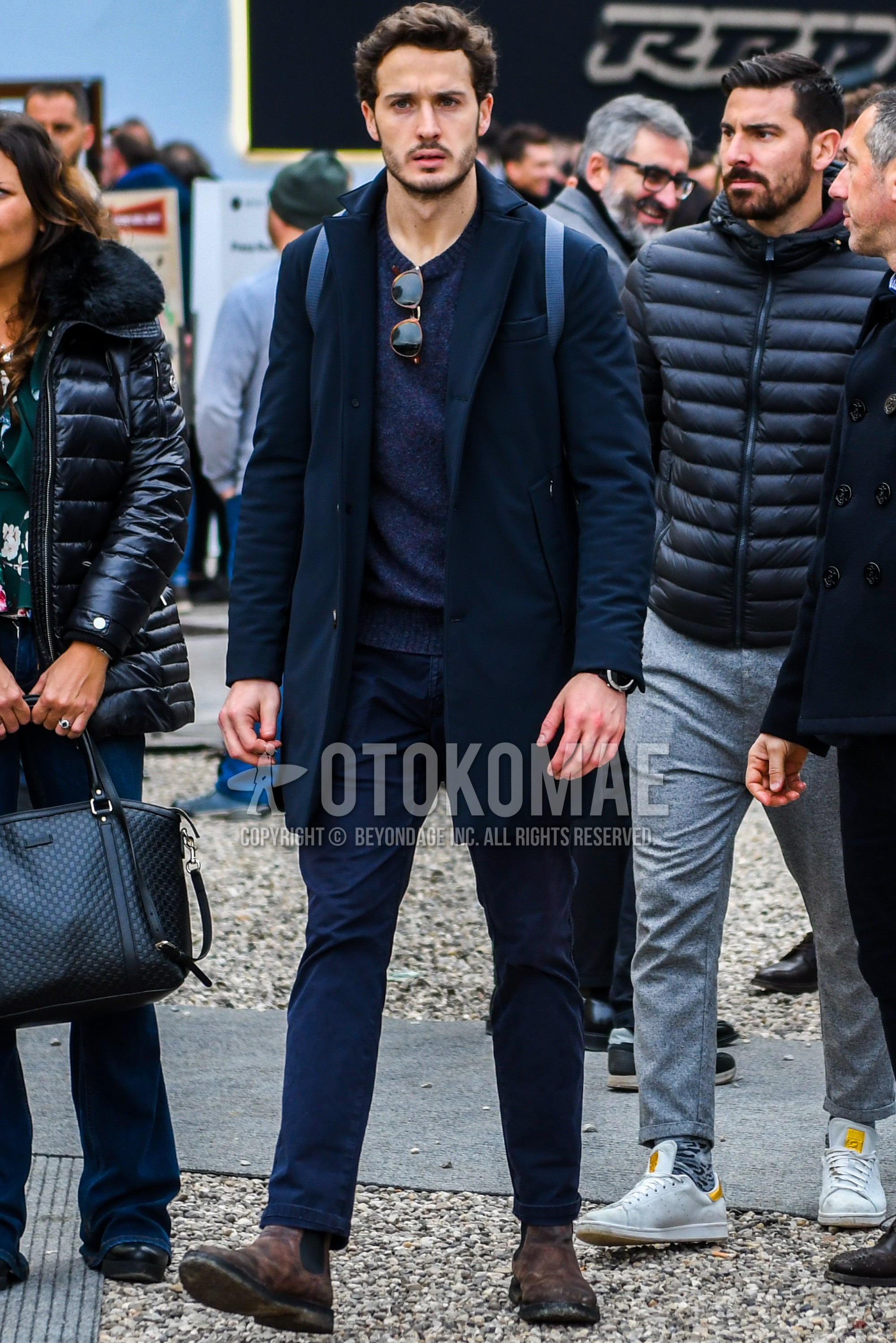 Men's autumn winter outfit with navy plain chester coat, gray plain sweater, navy plain chinos, brown side-gore boots.