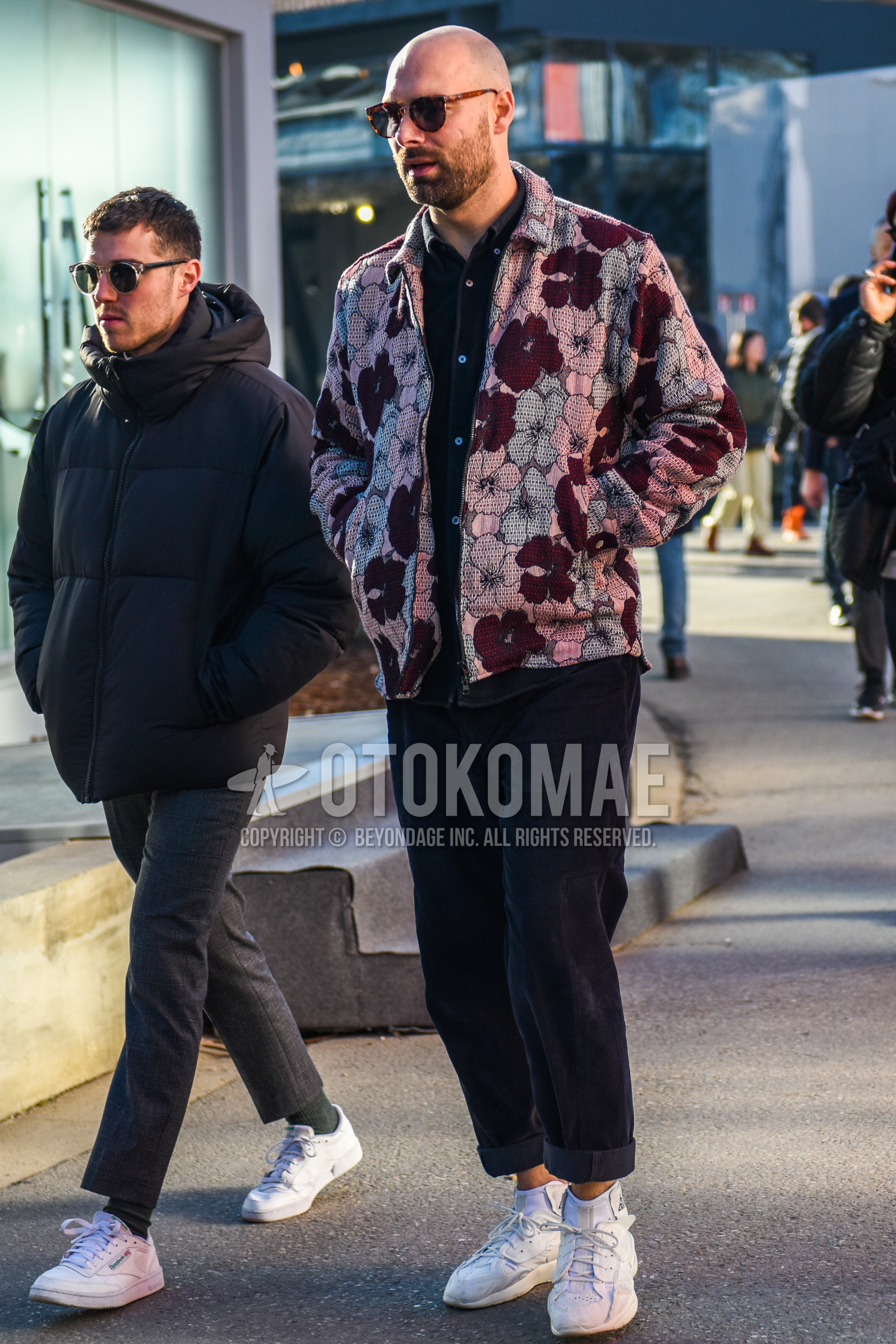 Men's winter outfit with brown tortoiseshell sunglasses, pink red botanical shirt jacket, black plain shirt, black plain winter pants (corduroy,velour), white high-cut sneakers.