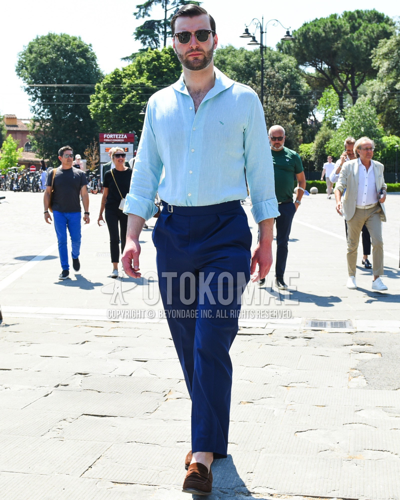 Men's spring summer outfit with brown tortoiseshell sunglasses, blue one point shirt, blue plain slacks, brown coin loafers leather shoes, brown suede shoes leather shoes.