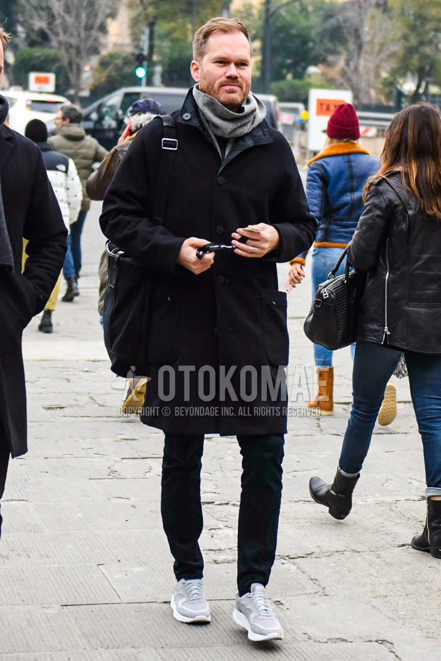 Men's winter outfit with gray plain scarf, black plain outerwear, dark gray plain slacks, gray low-cut sneakers, black plain shoulder bag.