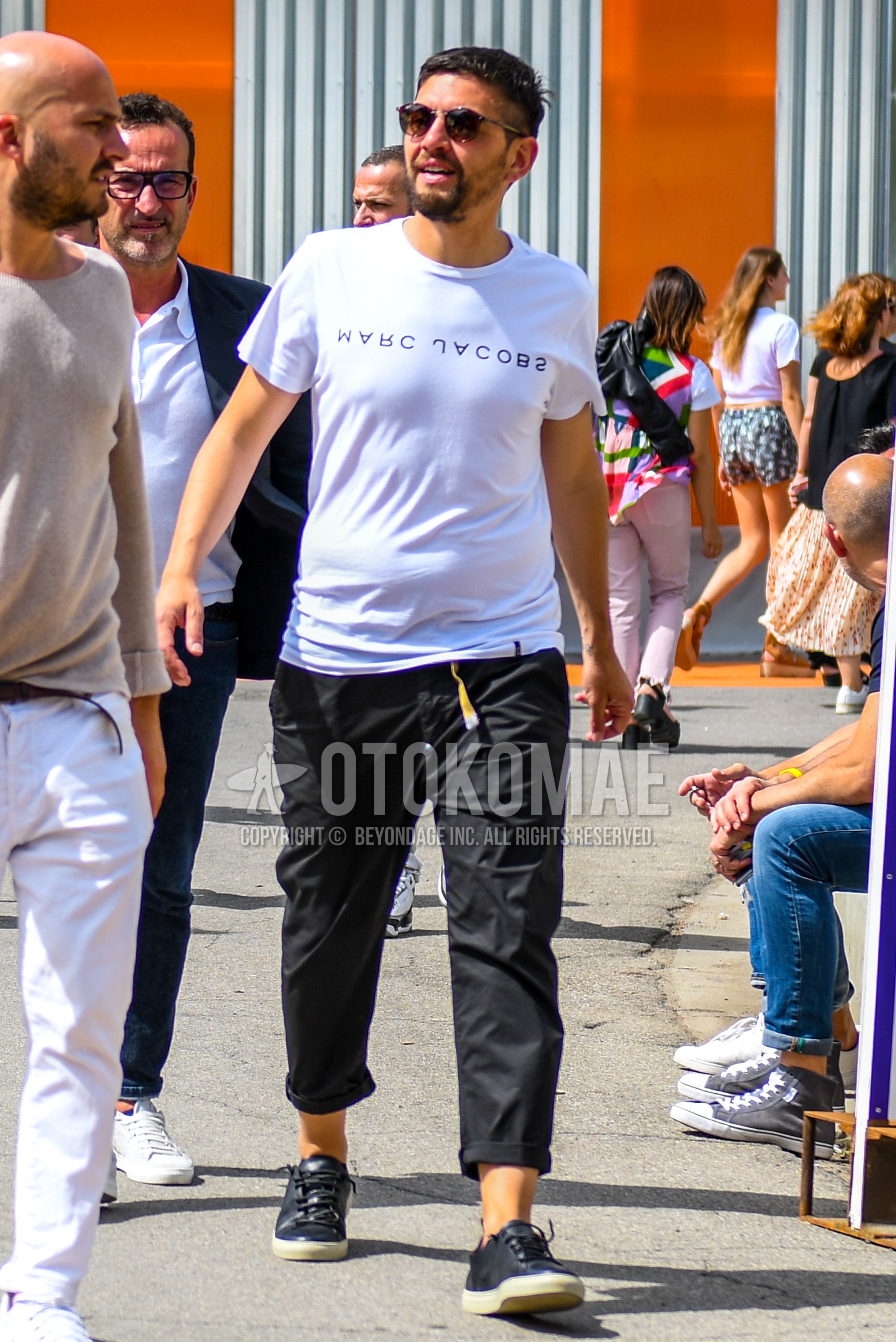 Men's summer outfit with plain sunglasses, white plain t-shirt, black plain cropped pants, black low-cut sneakers.
