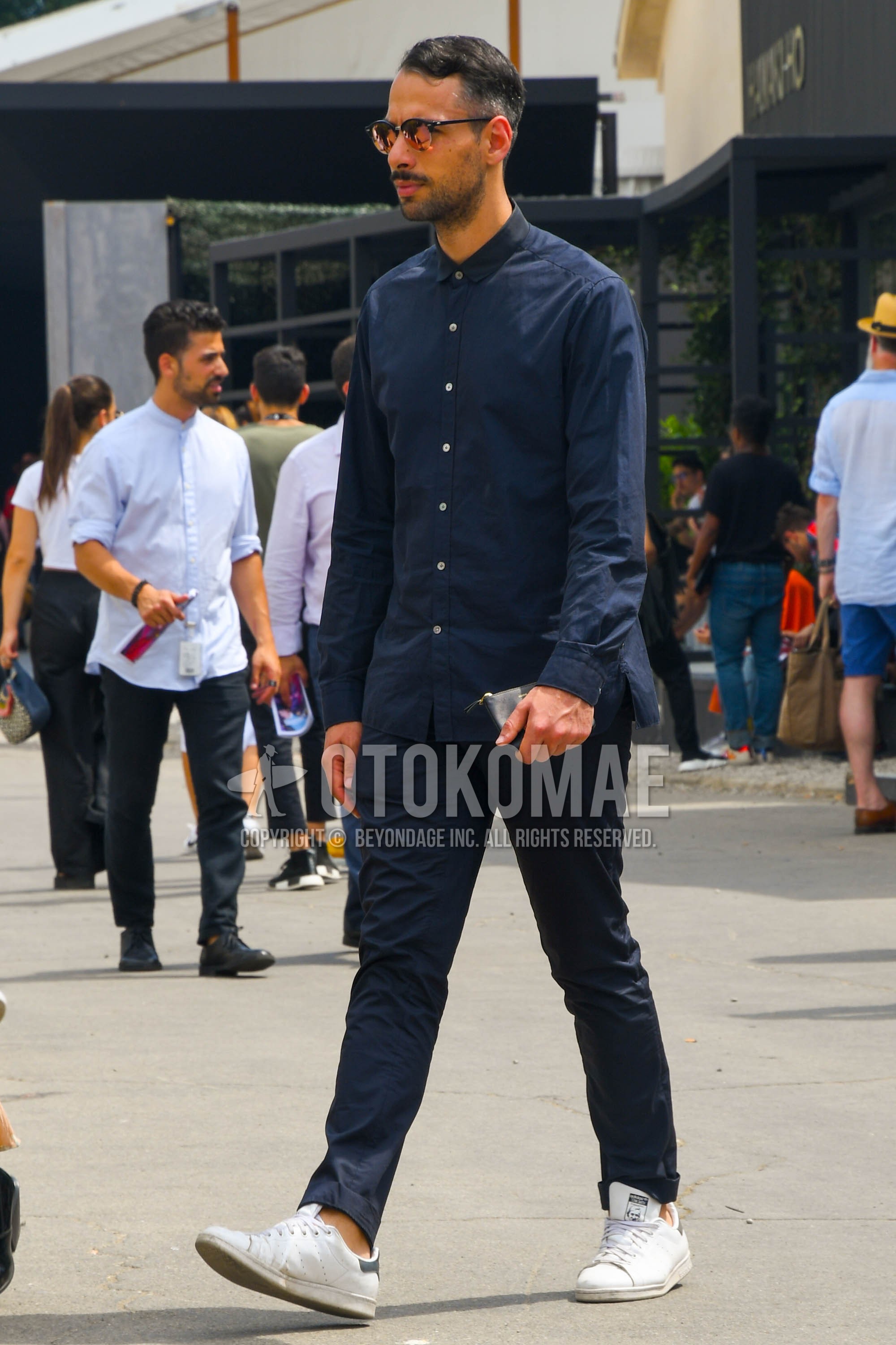 Men's spring summer autumn outfit with plain sunglasses, navy plain shirt, navy plain chinos, white low-cut sneakers.