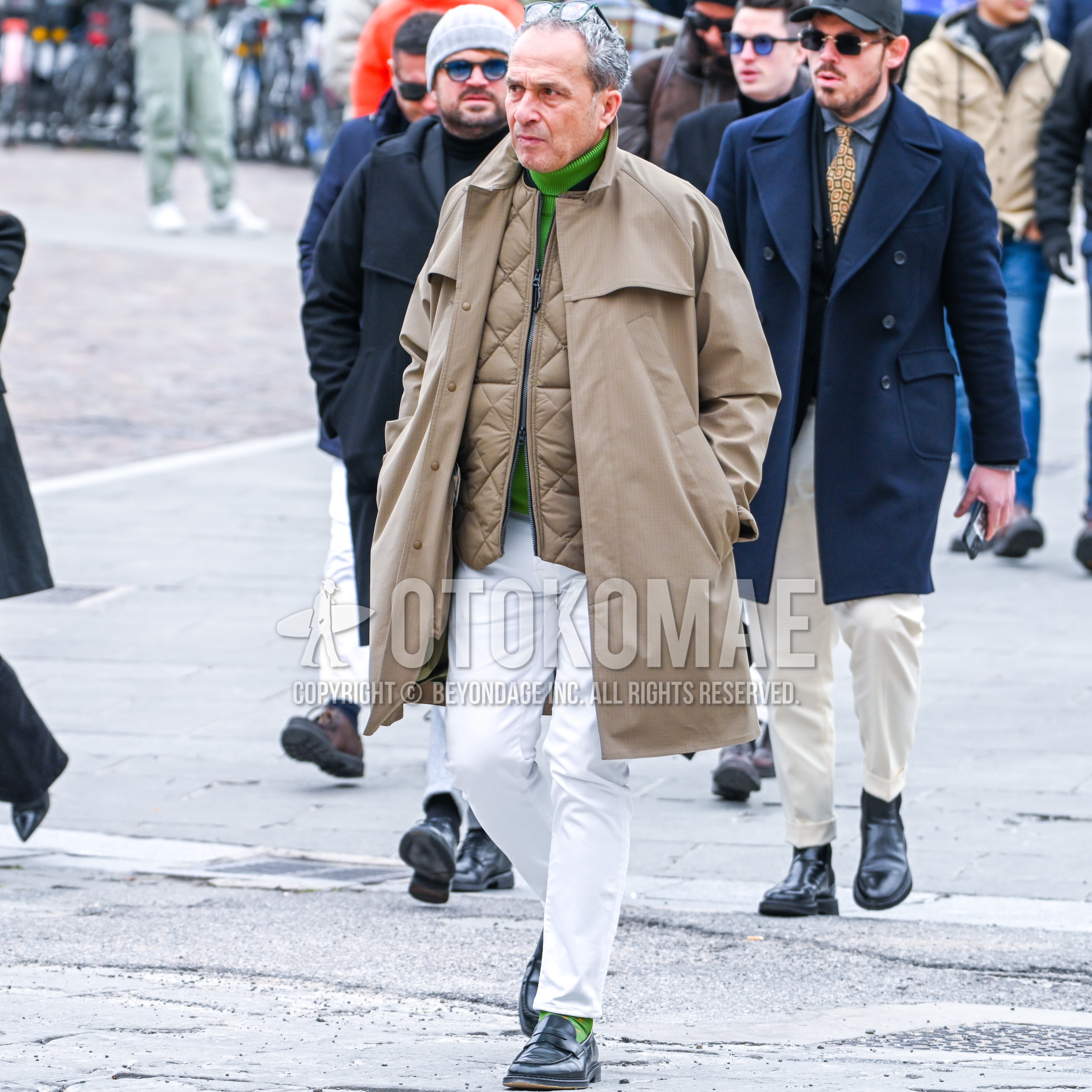 Men's outfit with green plain glasses, beige stripes stenkarrer coat, beige plain inner down, green plain turtleneck knit, white plain cotton pants, green socks socks, black coin loafers leather shoes.