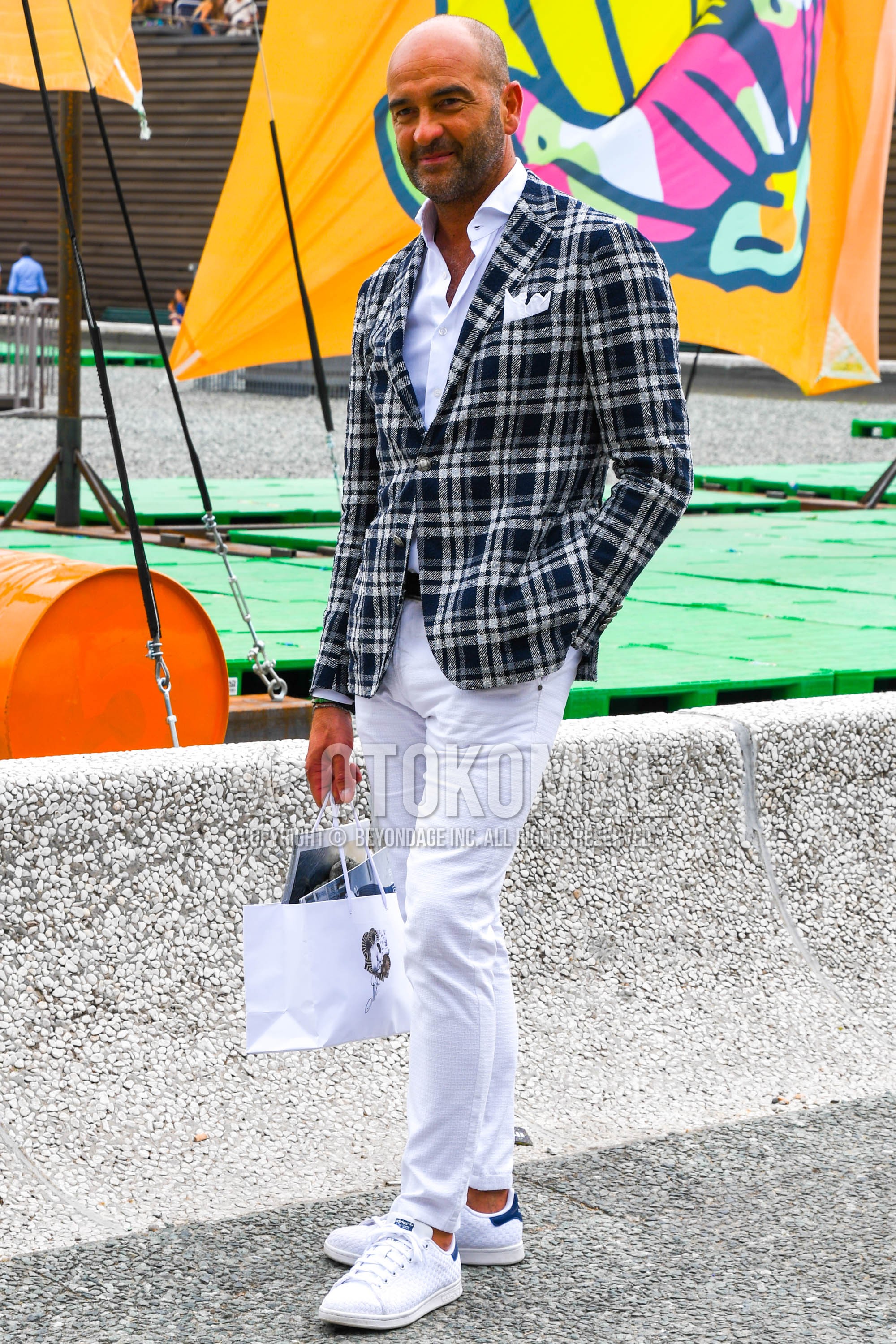 Men's spring summer autumn outfit with navy white check tailored jacket, white plain denim/jeans, white low-cut sneakers.