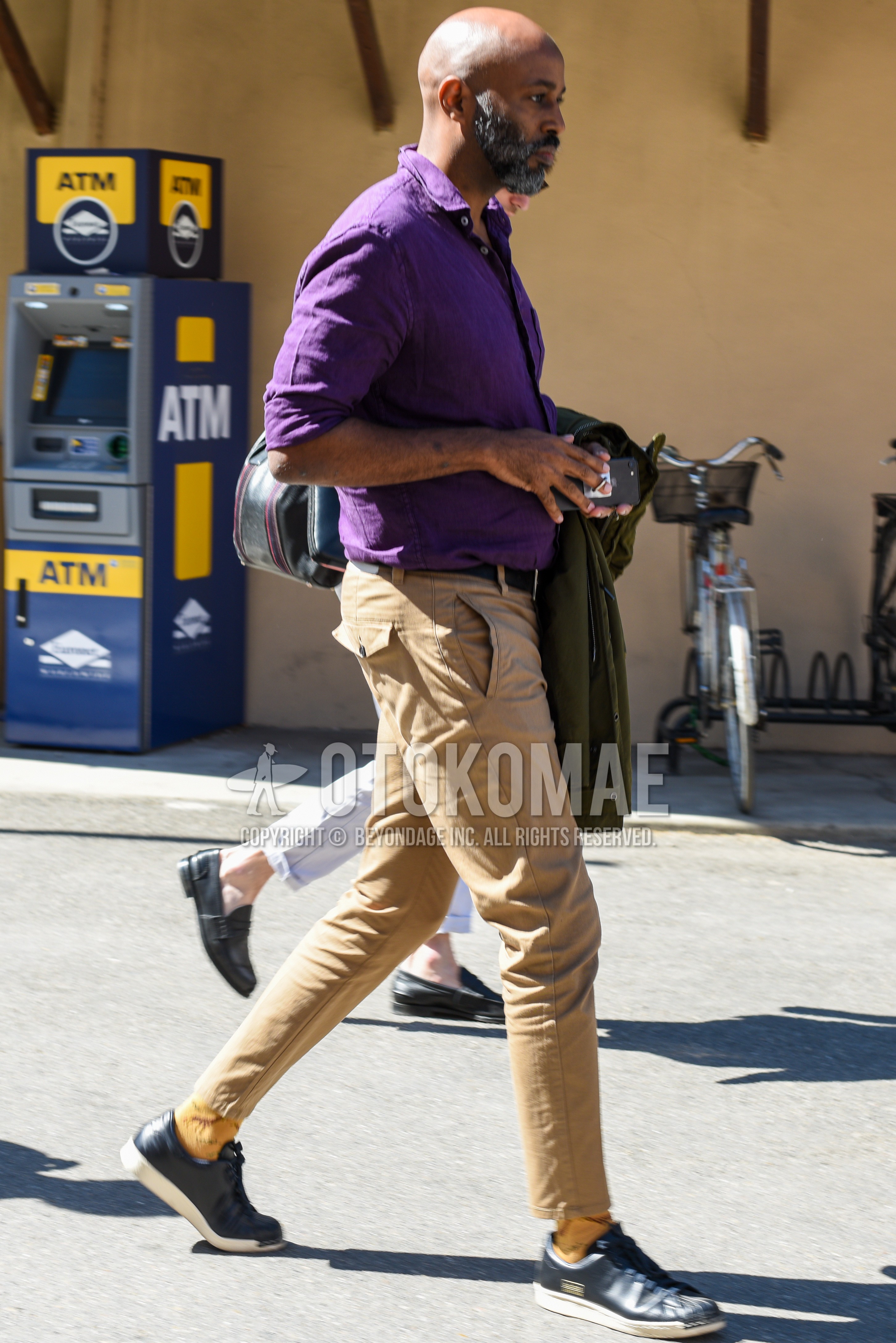 Men's spring summer outfit with purple plain shirt, black plain leather belt, beige plain chinos, beige socks socks, navy low-cut sneakers.