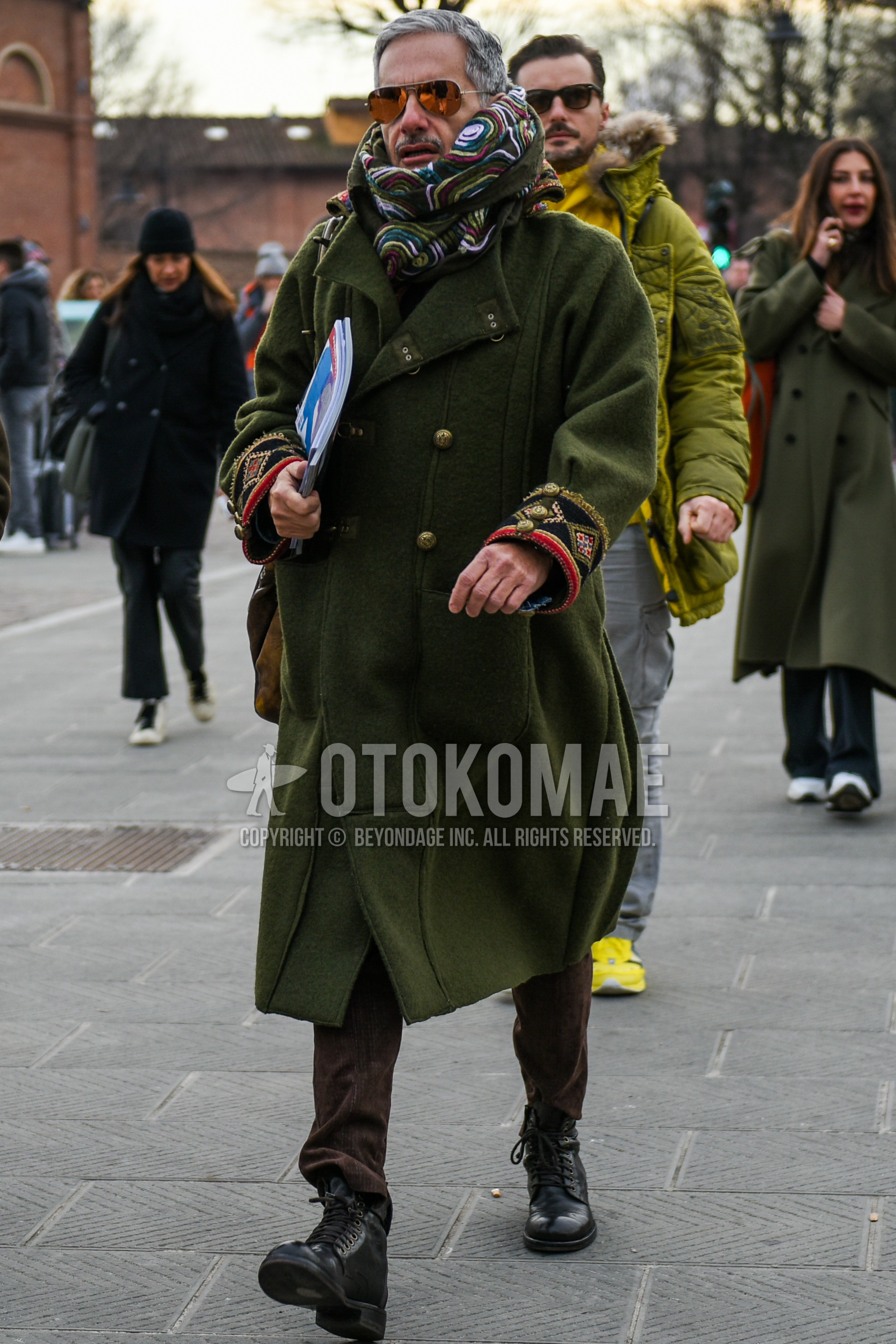 Men's autumn winter outfit with gold plain sunglasses, multi-color scarf scarf, olive green plain outerwear, brown plain winter pants (corduroy,velour), black work boots.