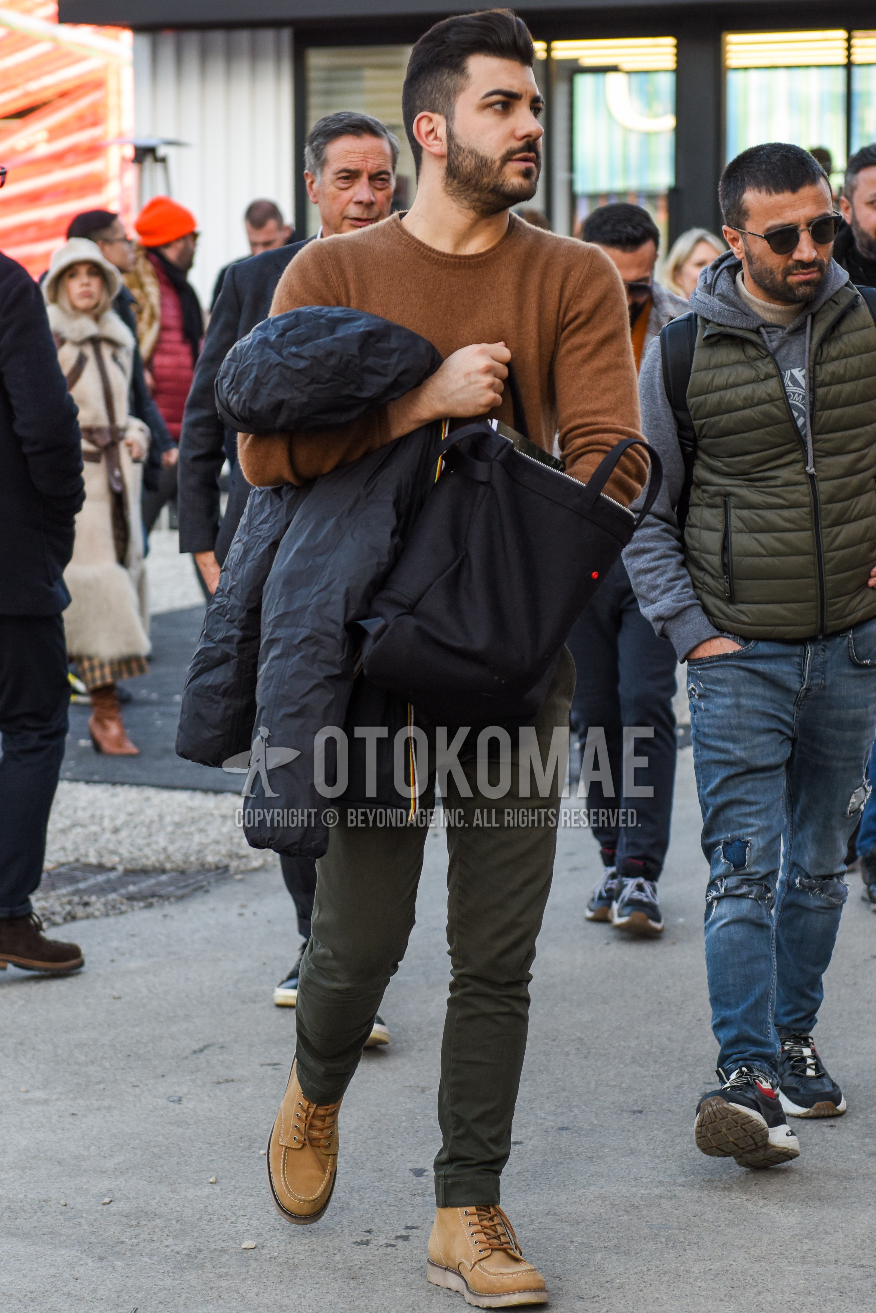 Men's spring autumn outfit with brown plain sweater, olive green plain chinos, beige work boots.
