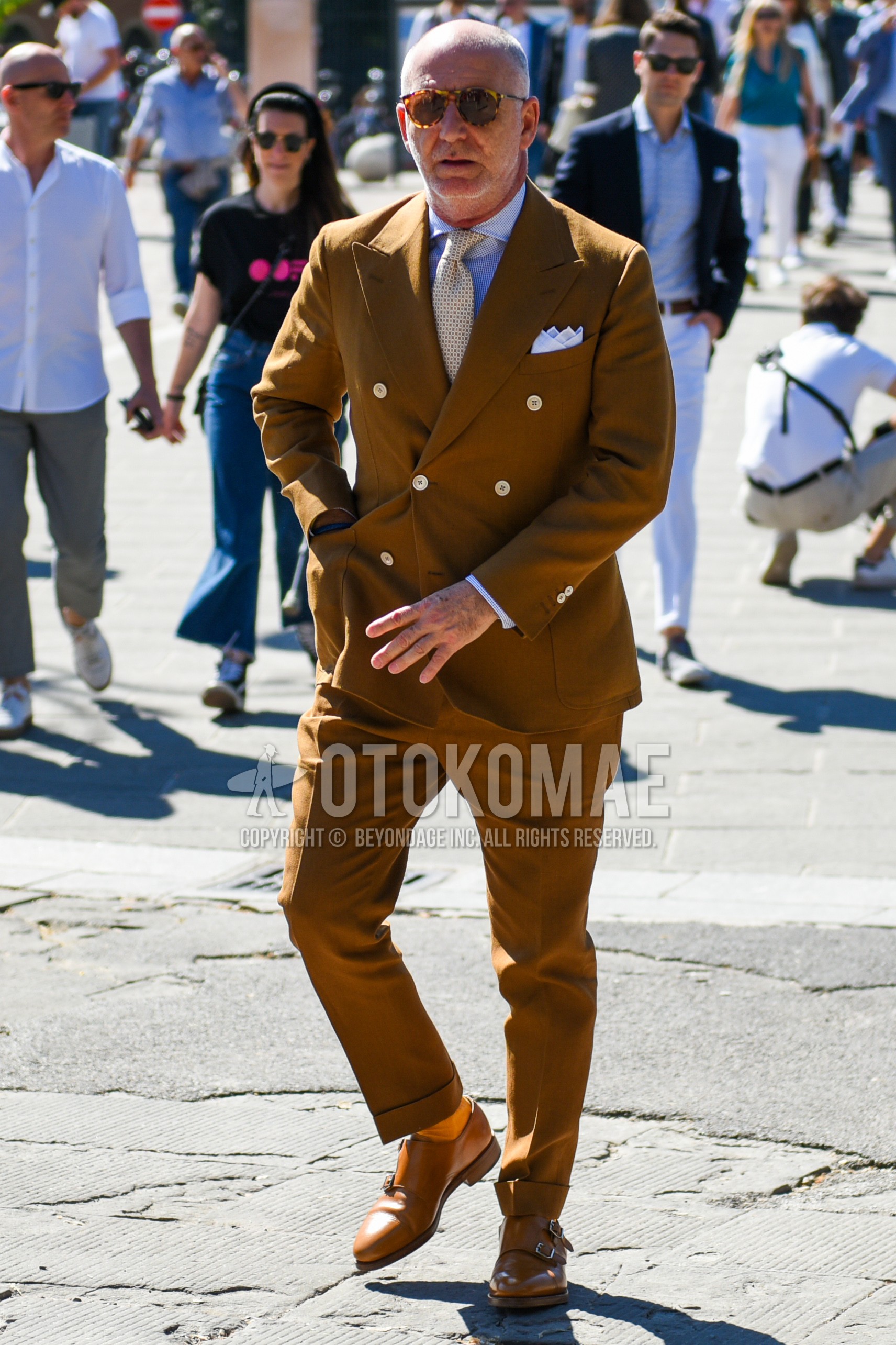 Men's spring autumn outfit with brown tortoiseshell sunglasses, white tops/innerwear shirt, orange plain socks, brown monk shoes leather shoes, beige plain suit, beige necktie necktie.