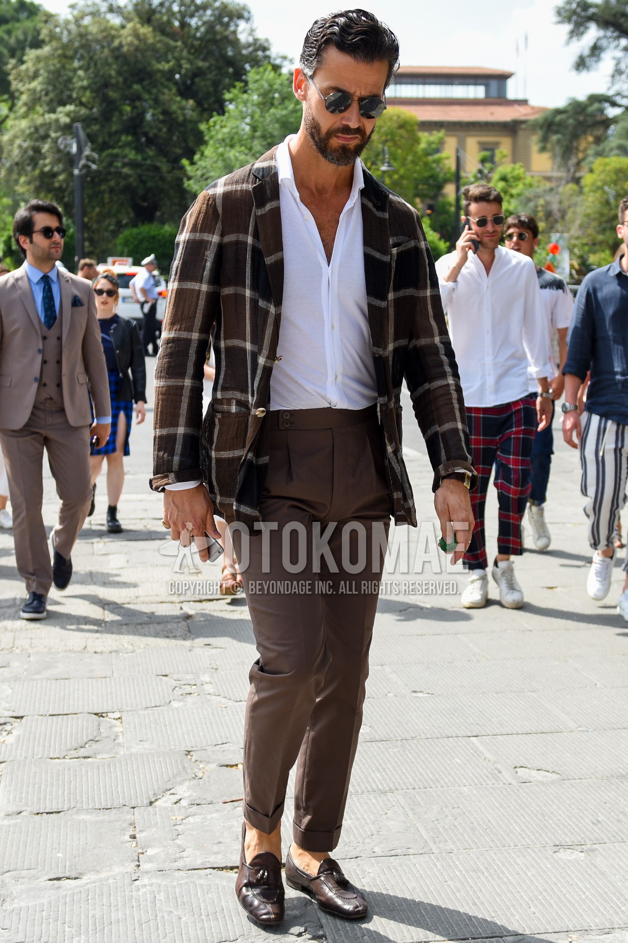 Men's spring summer autumn outfit with black plain sunglasses, brown check tailored jacket, white plain shirt, brown plain beltless pants, brown tassel loafers leather shoes.