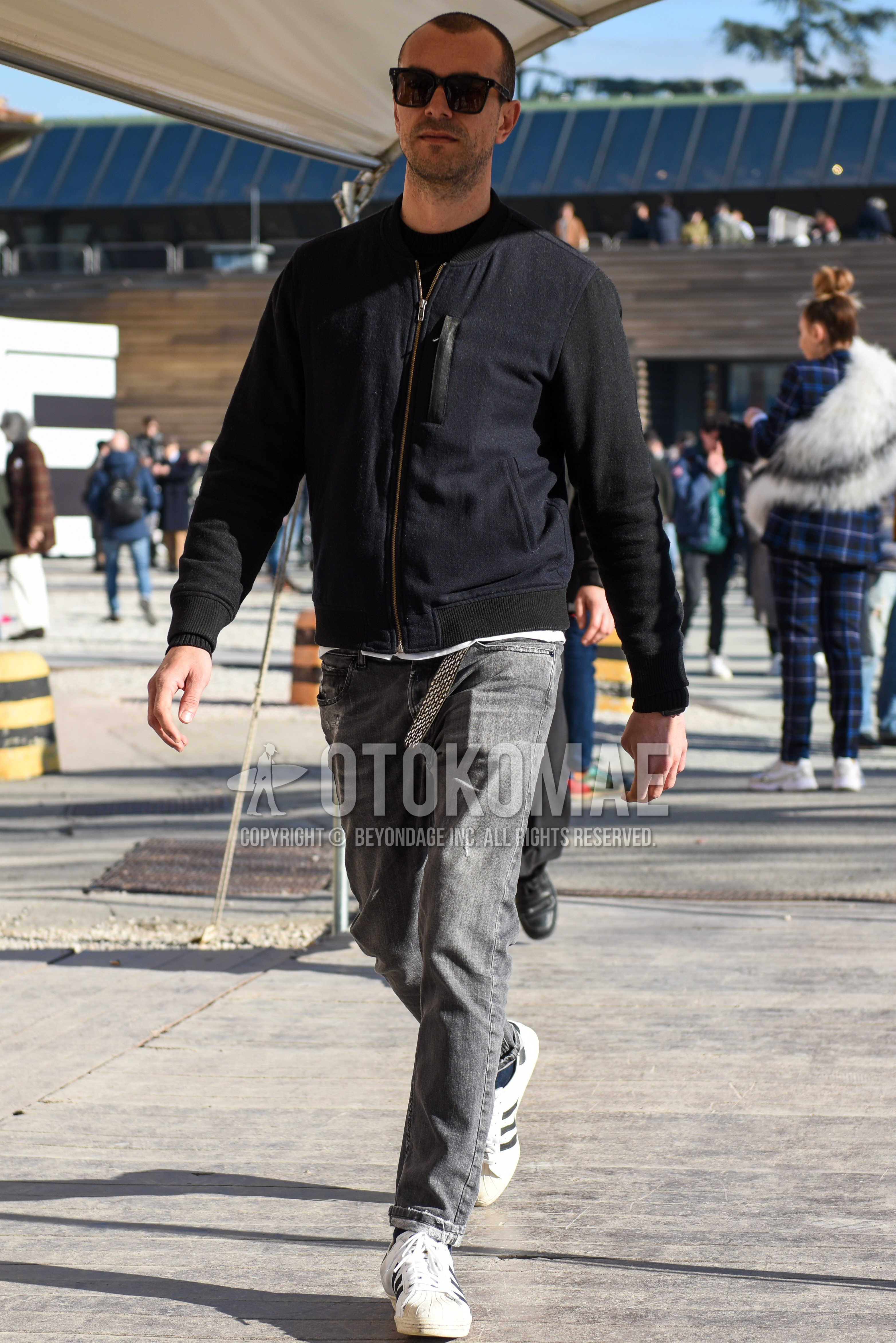 Men's autumn winter outfit with black plain sunglasses, dark gray plain MA-1, gray plain denim/jeans, white low-cut sneakers.