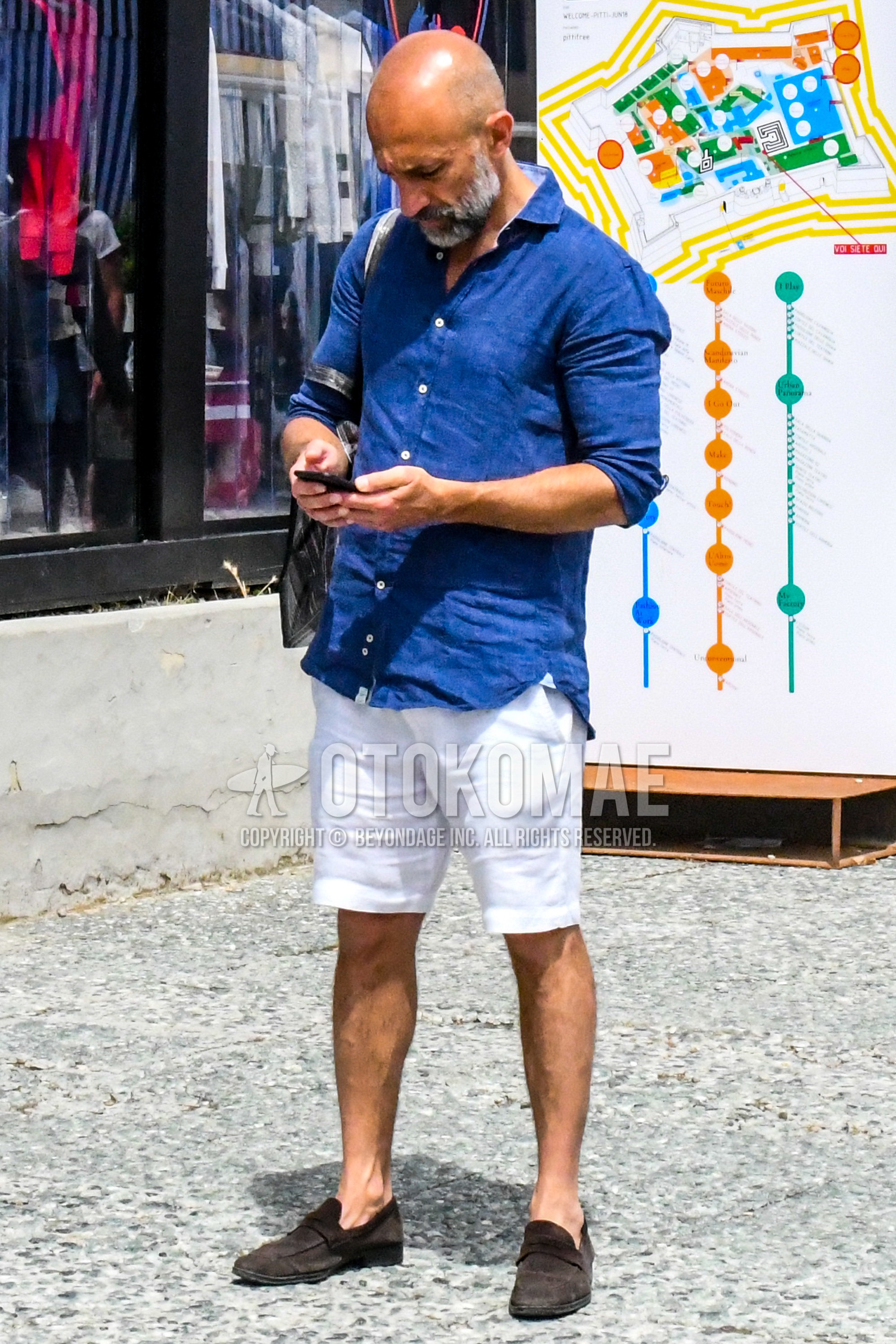 Men's summer outfit with blue plain shirt, white plain short pants, brown coin loafers leather shoes.