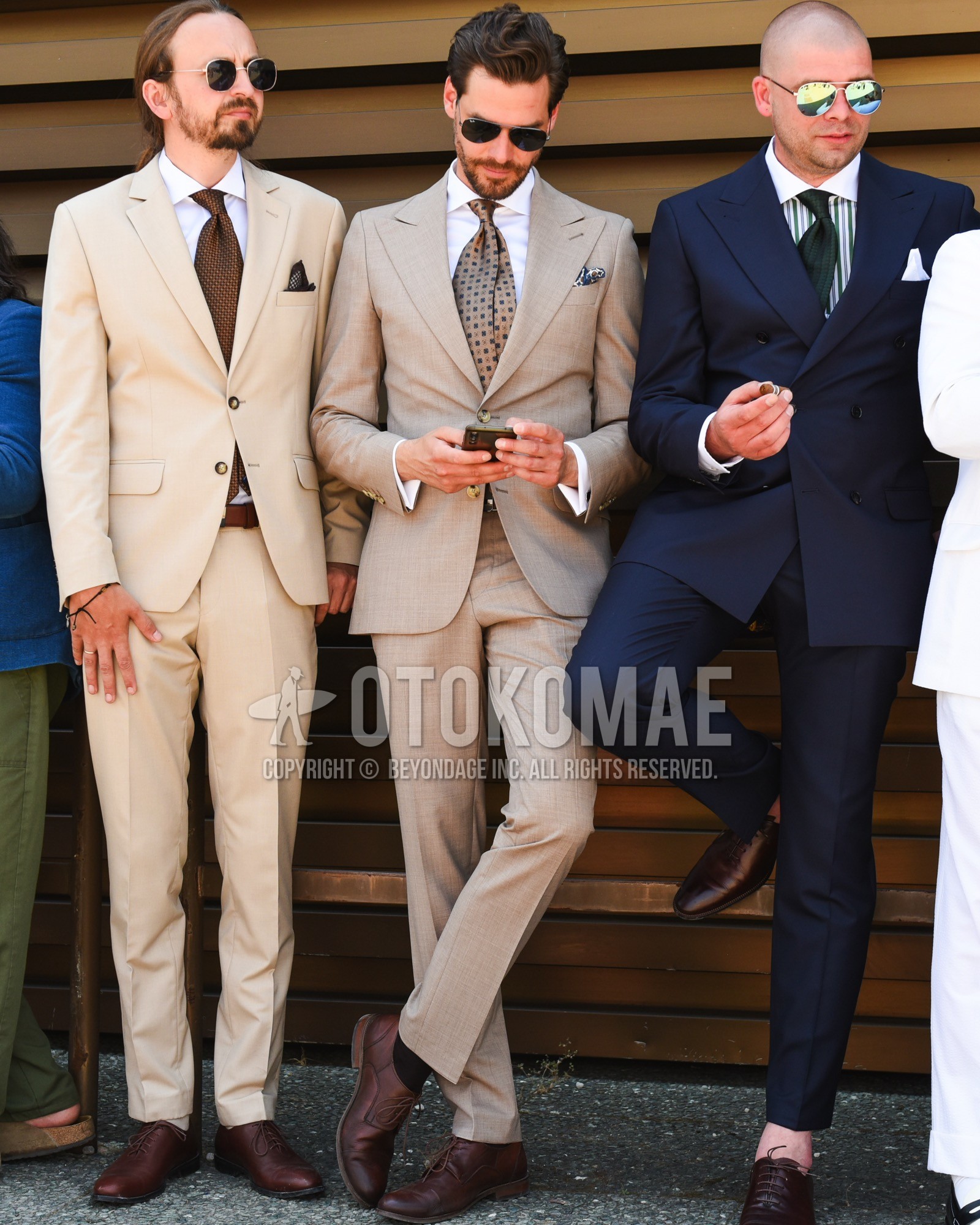 Men's spring summer outfit with black plain sunglasses, white plain shirt, black plain socks, brown straight-tip shoes leather shoes, beige check suit, beige dots necktie.