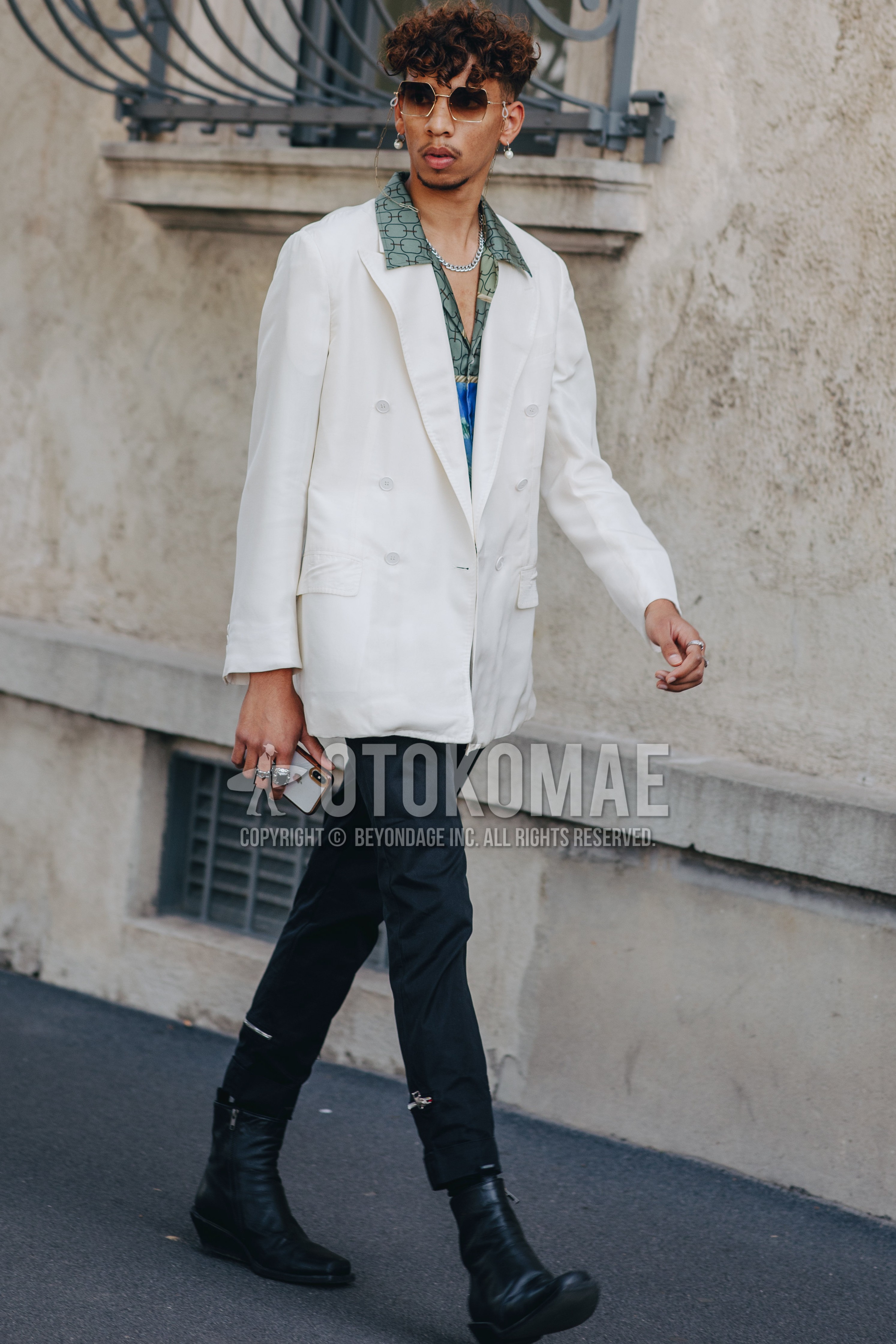 Men's spring summer outfit with gold plain sunglasses, white plain tailored jacket, green tops/innerwear shirt, black plain bottoms, black  boots.