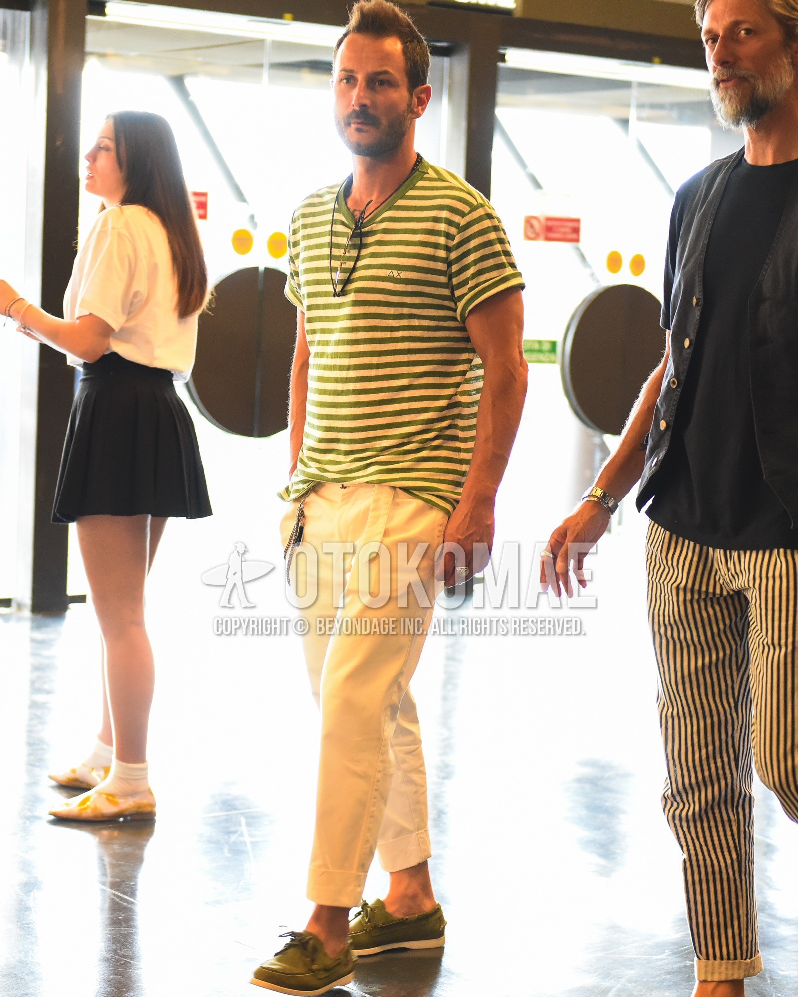 Men's spring summer outfit with green horizontal stripes t-shirt, white plain cotton pants, olive green moccasins/deck shoes leather shoes.