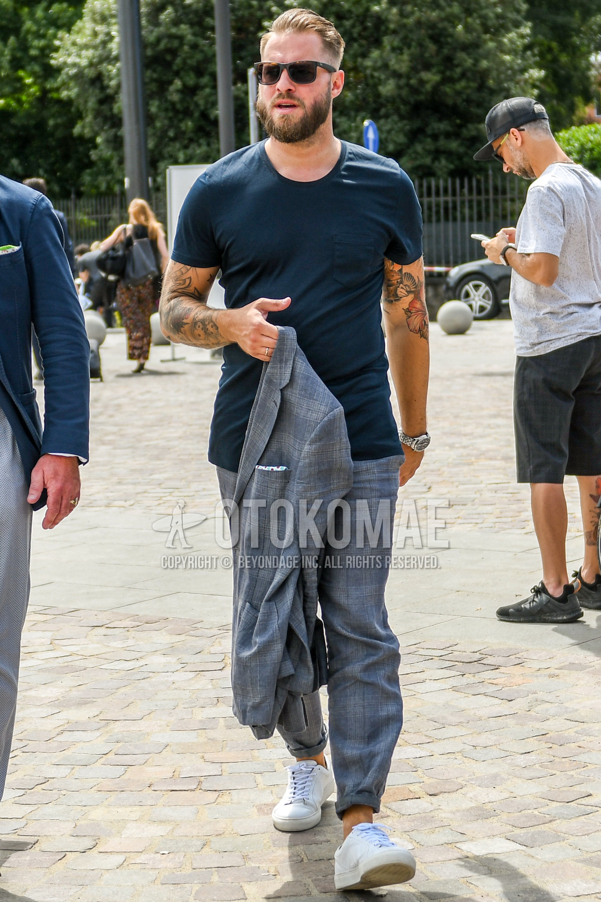 Men's summer outfit with plain sunglasses, navy plain t-shirt, gray check cotton pants, white low-cut sneakers.