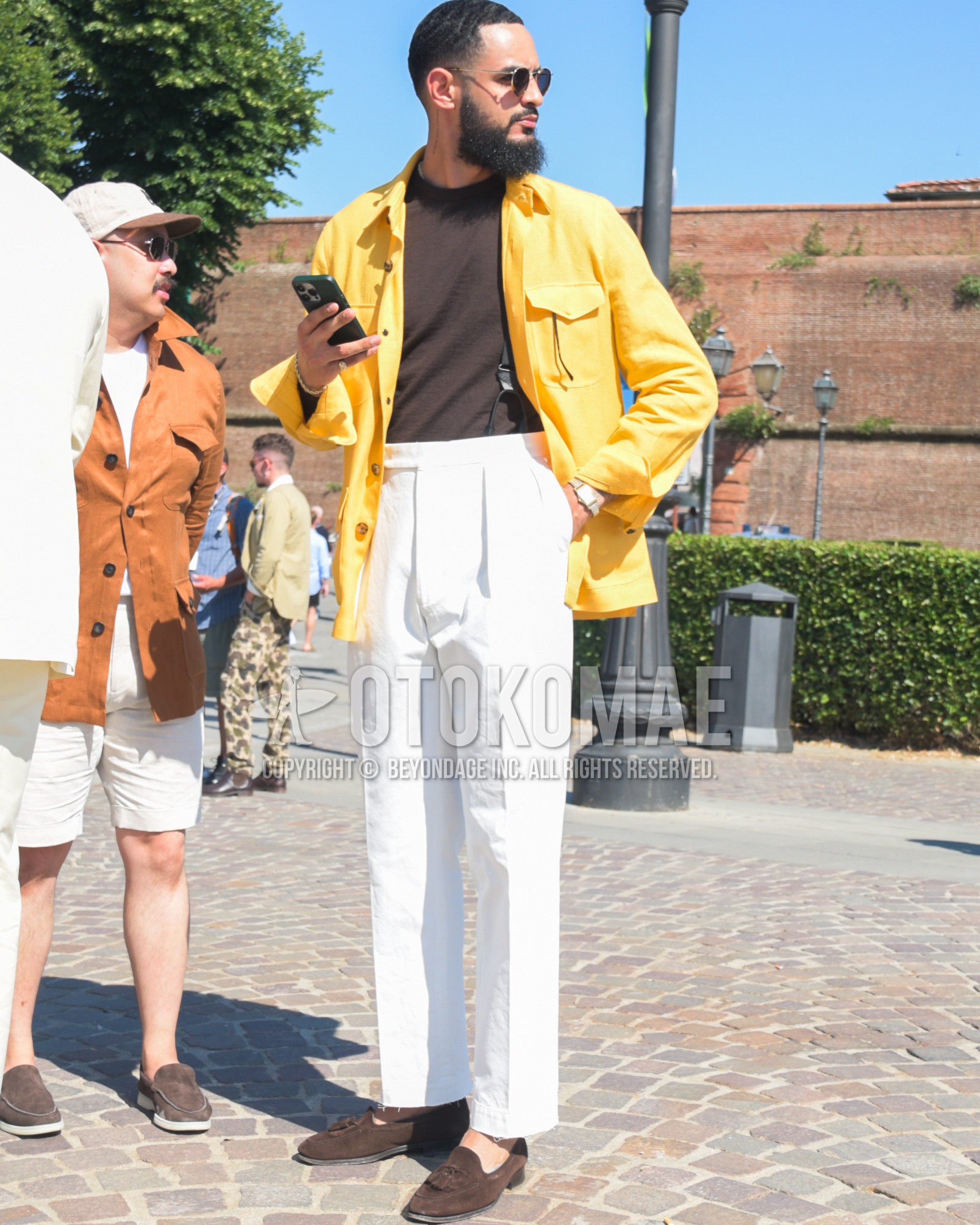 Men's spring summer autumn outfit with gold plain sunglasses, yellow plain shirt jacket, brown plain t-shirt, white plain slacks, white plain pleated pants, brown tassel loafers leather shoes.