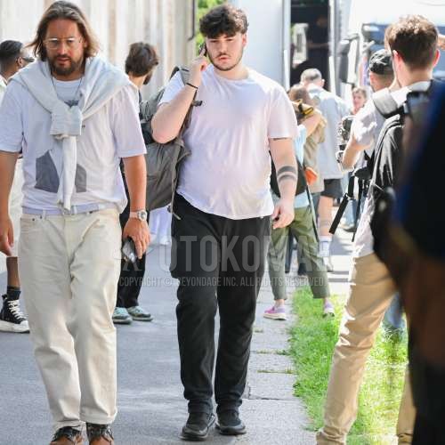 白無地のTシャツ、黒無地のボトムス、黒ローカットのスニーカー、オリーブグリーン無地のバックパックを合わせた夏春のメンズコーデ・着こなし。