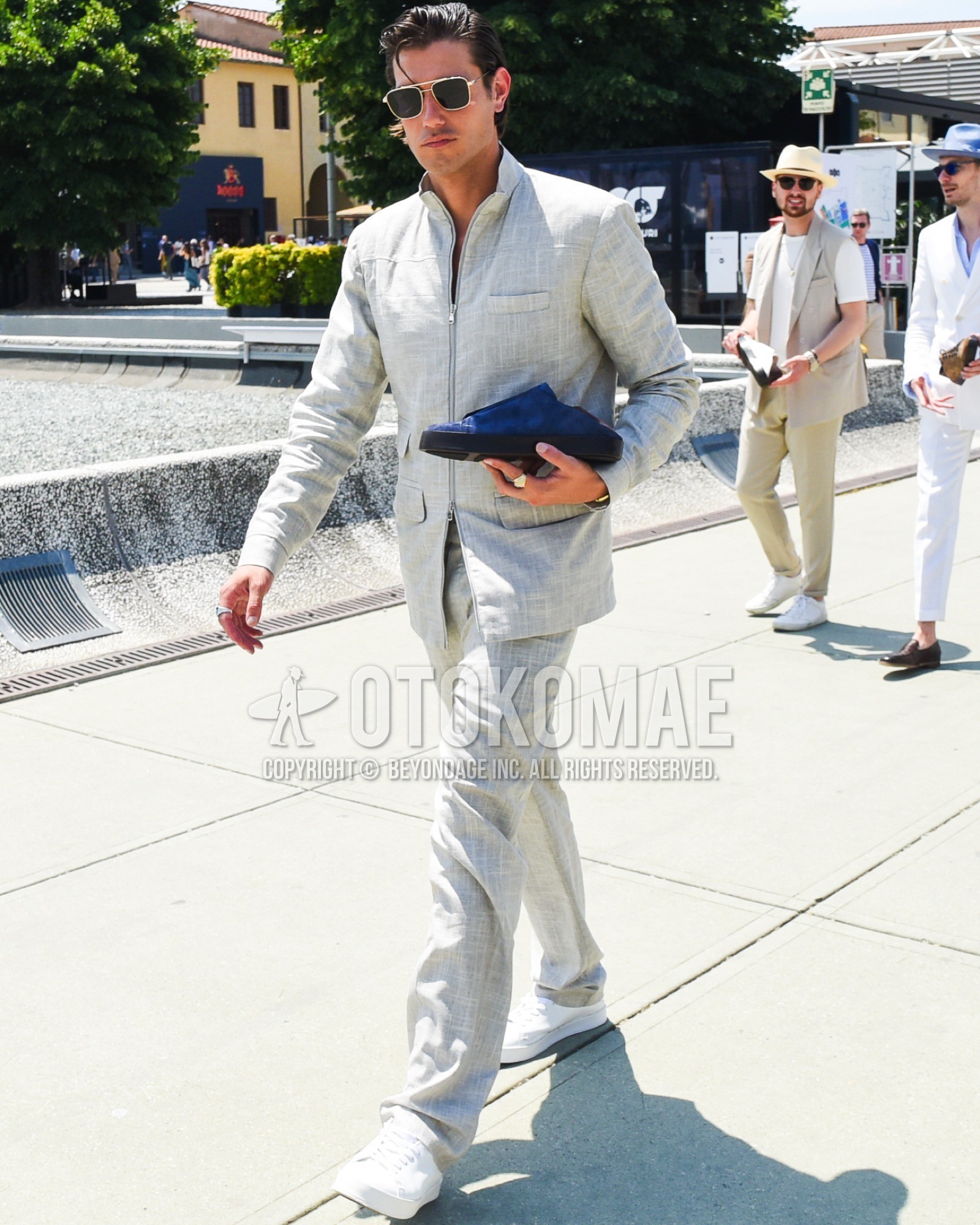 Men's spring summer outfit with gold plain sunglasses, white low-cut sneakers, gray plain casual setup.