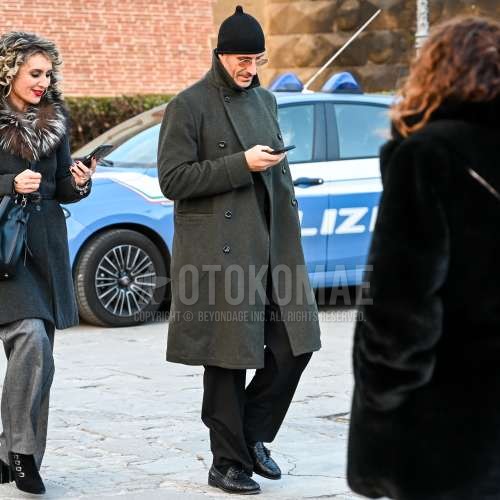 黒無地のニットキャップ、ラウンドのシルバー無地のメガネ、グレー無地のアルスターコート、ダークグレー無地のスラックス、黒無地のソックス、黒タッセルローファーの革靴を合わせた秋冬のメンズコーデ・着こなし。