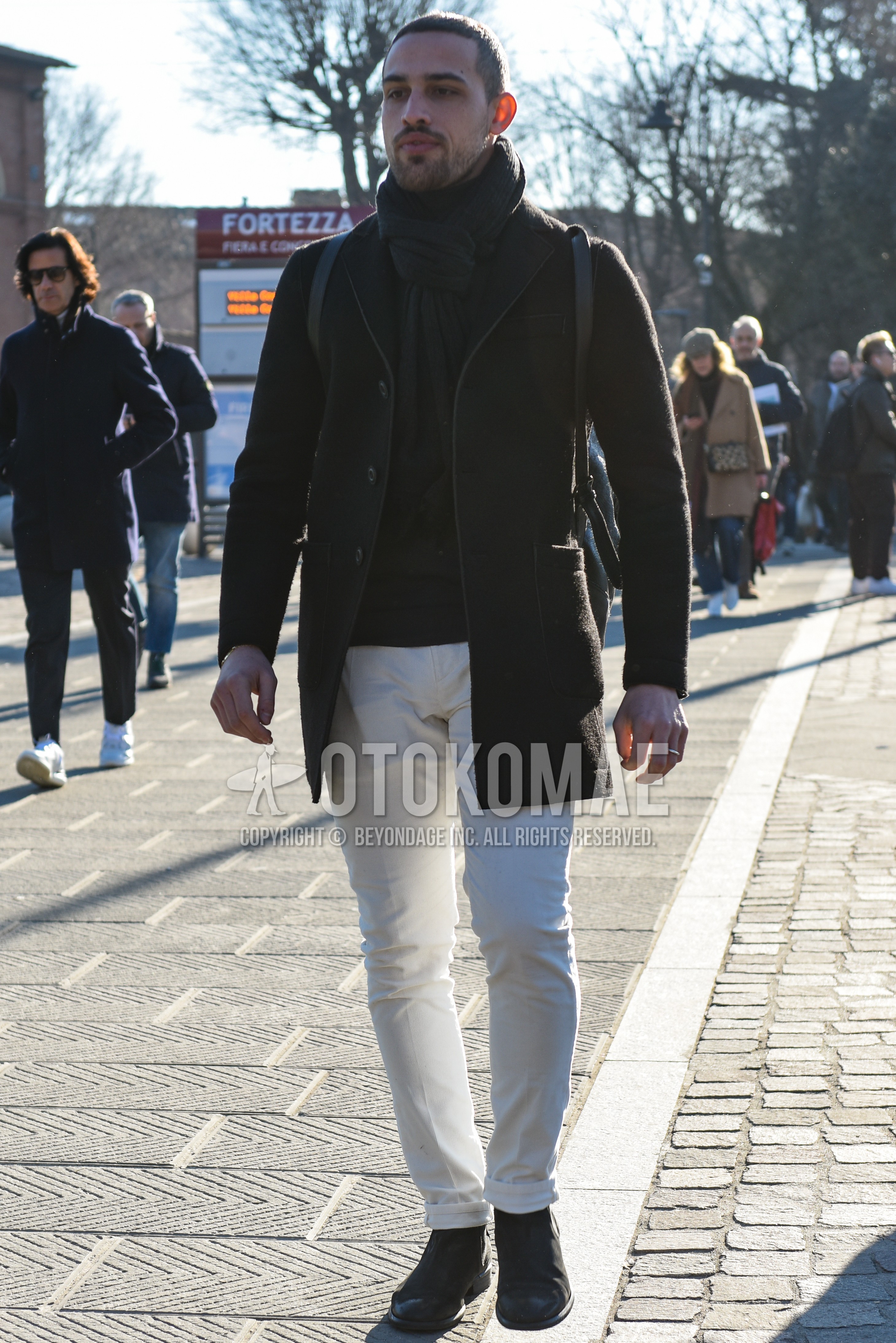Men's autumn winter outfit with black plain scarf, black plain chester coat, white plain cotton pants, black side-gore boots.