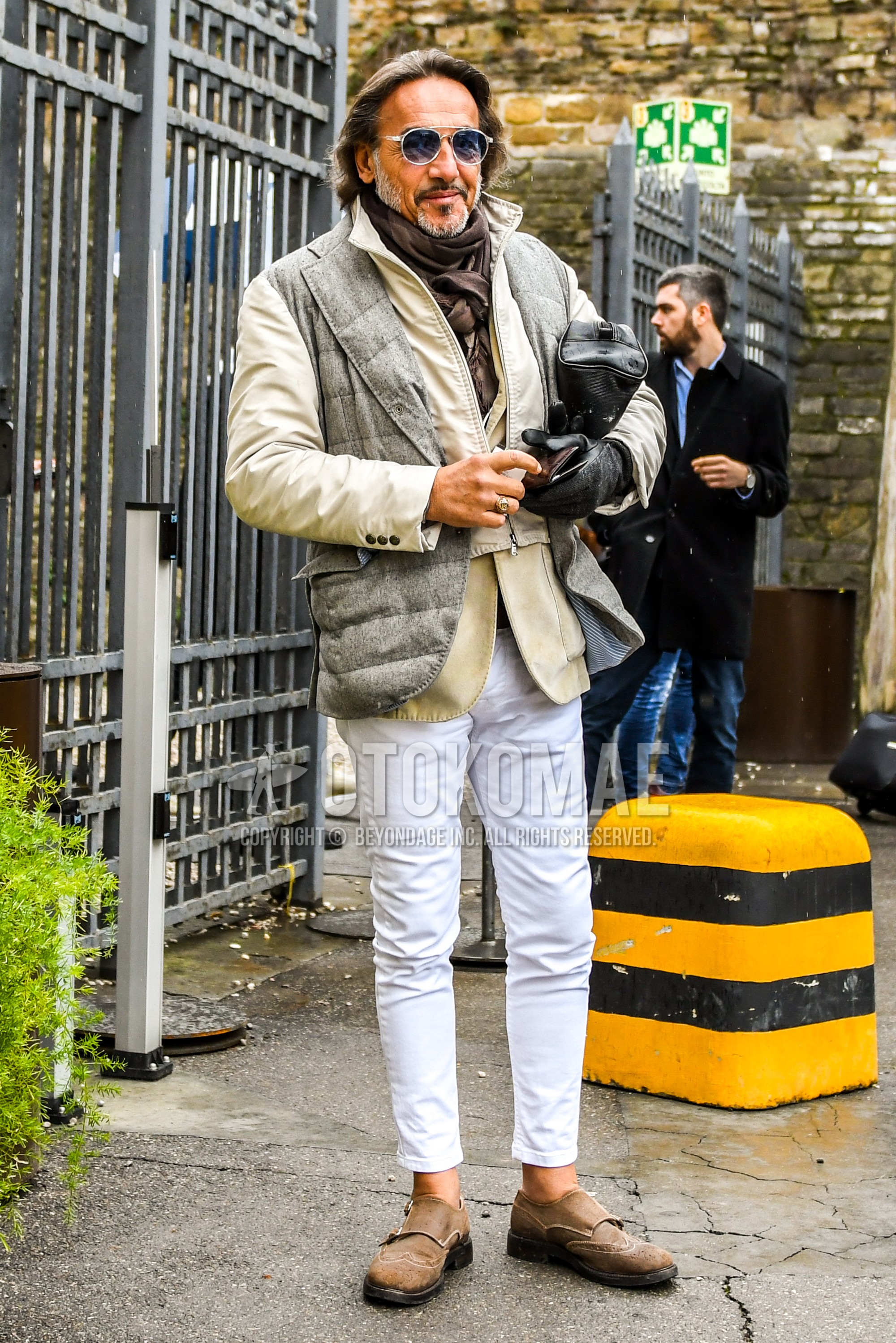 Men's autumn winter outfit with silver plain sunglasses, brown plain scarf, gray beige plain outerwear, beige plain tailored jacket, white plain cotton pants, white plain ankle pants, beige monk shoes leather shoes.