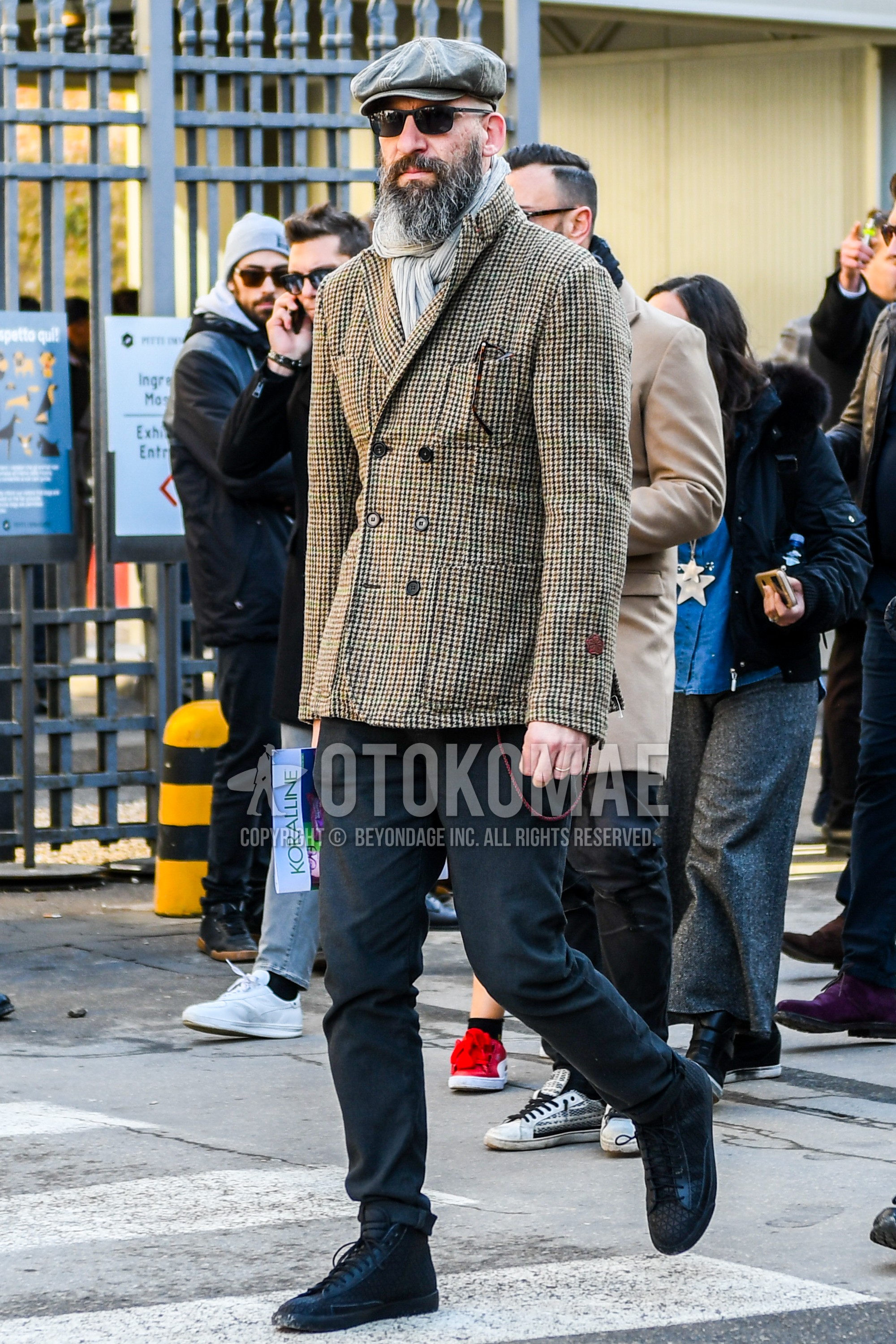Men's autumn winter outfit with plain cap, plain sunglasses, beige plain scarf, brown check tailored jacket, gray plain slacks, black high-cut sneakers.