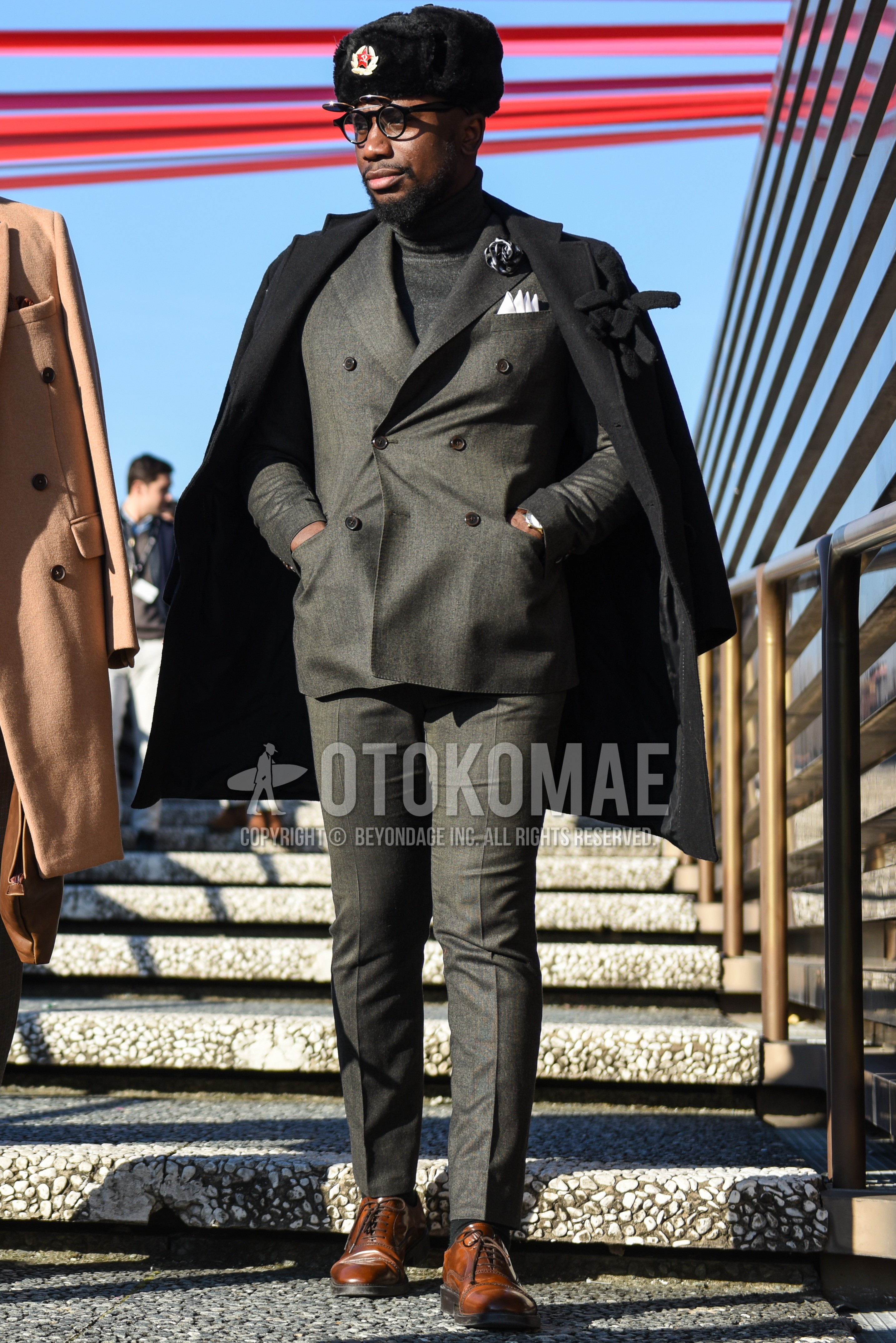 Men's autumn winter outfit with black one point cap, black plain chester coat, gray plain turtleneck knit, dark gray plain socks, brown wing-tip shoes leather shoes, gray plain suit.