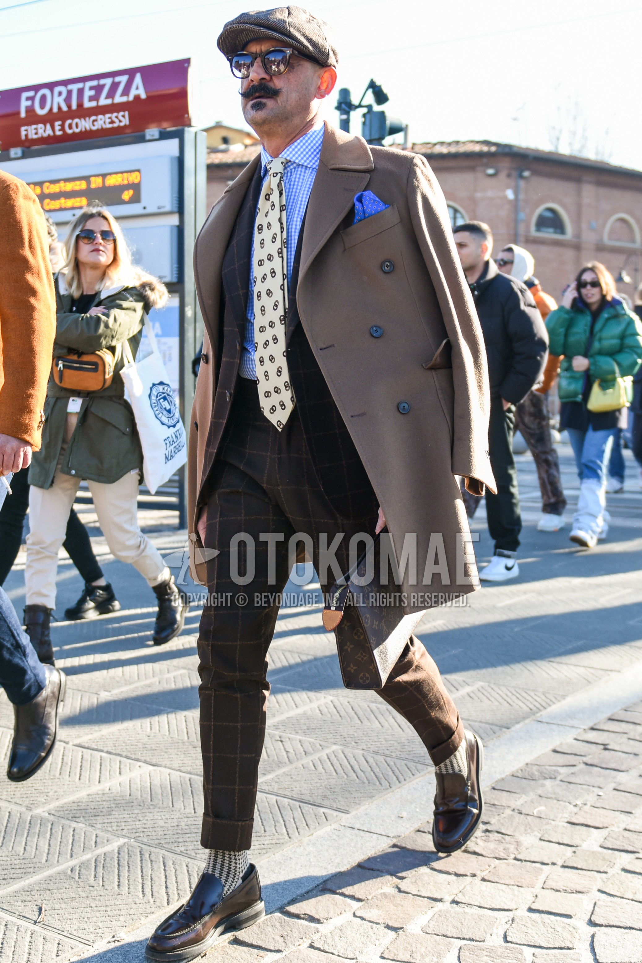 Men's autumn winter outfit with beige herringbone hunting cap, beige plain chester coat, light blue check shirt, beige socks socks, brown  loafers leather shoes, brown bag clutch bag/second bag/drawstring bag, brown check suit, white necktie necktie.
