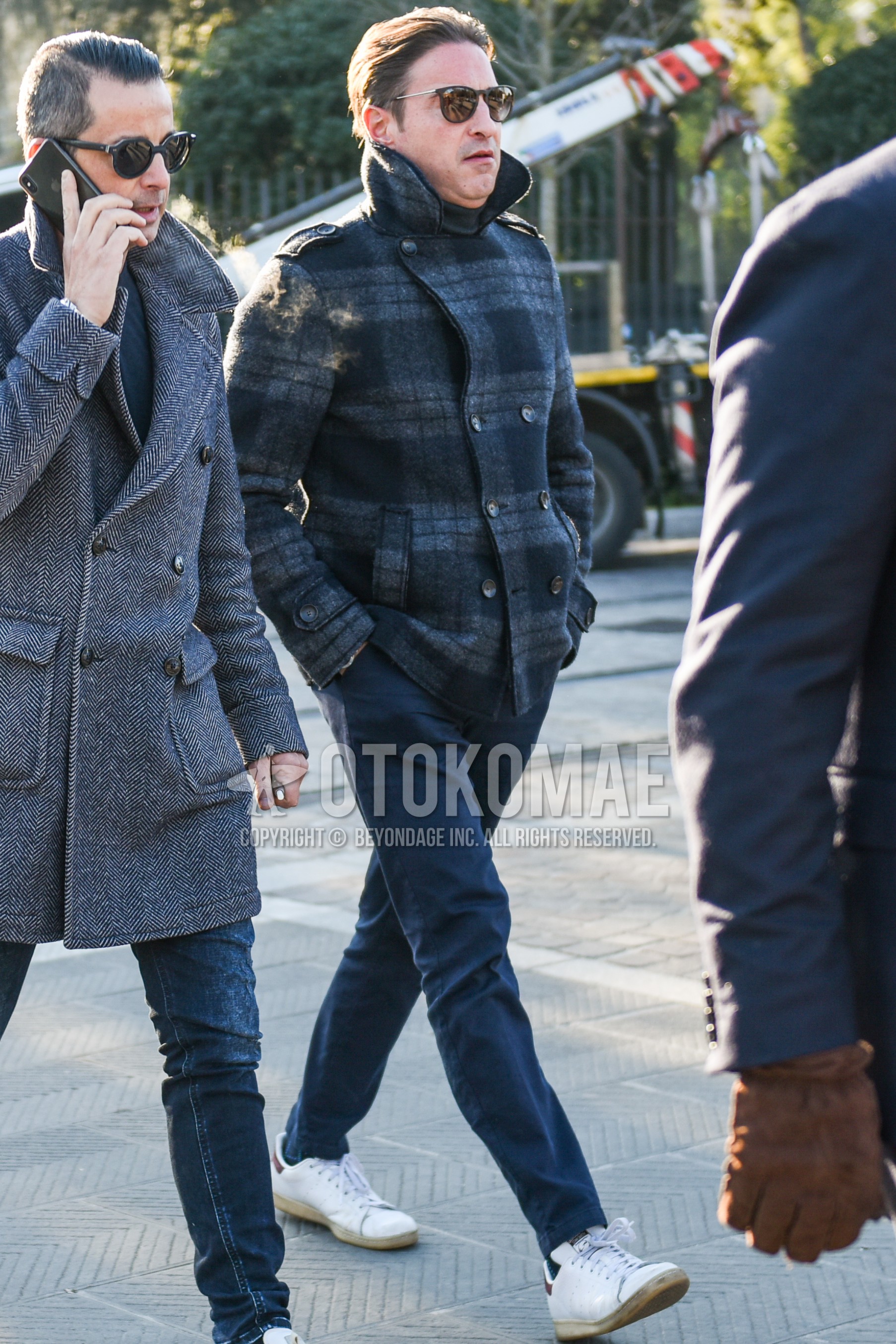 Men's autumn winter outfit with black plain sunglasses, gray check p coat, dark gray plain chinos, white low-cut sneakers.