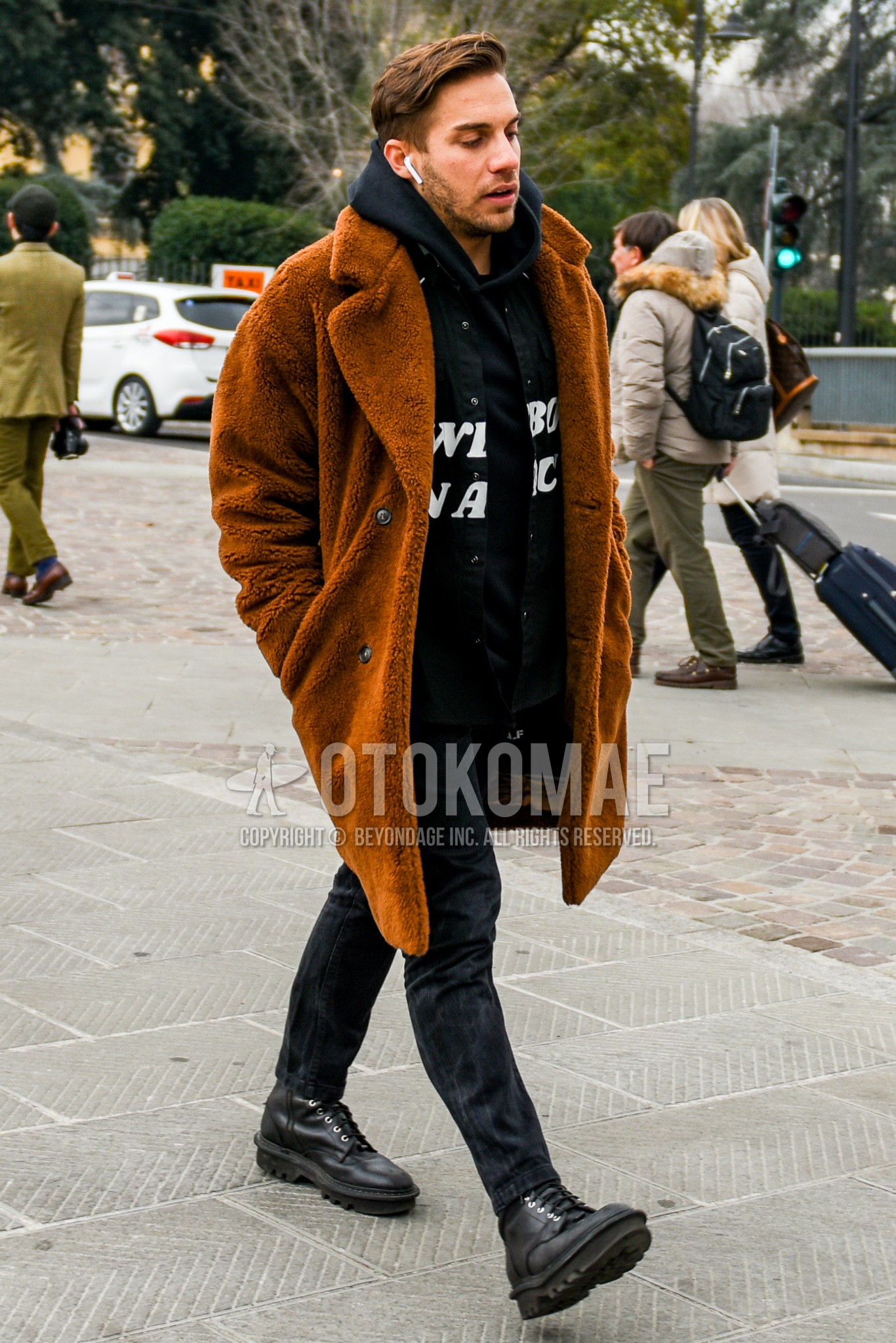 Men's winter outfit with brown plain chester coat, black graphic hoodie, dark gray plain denim/jeans, black  boots.