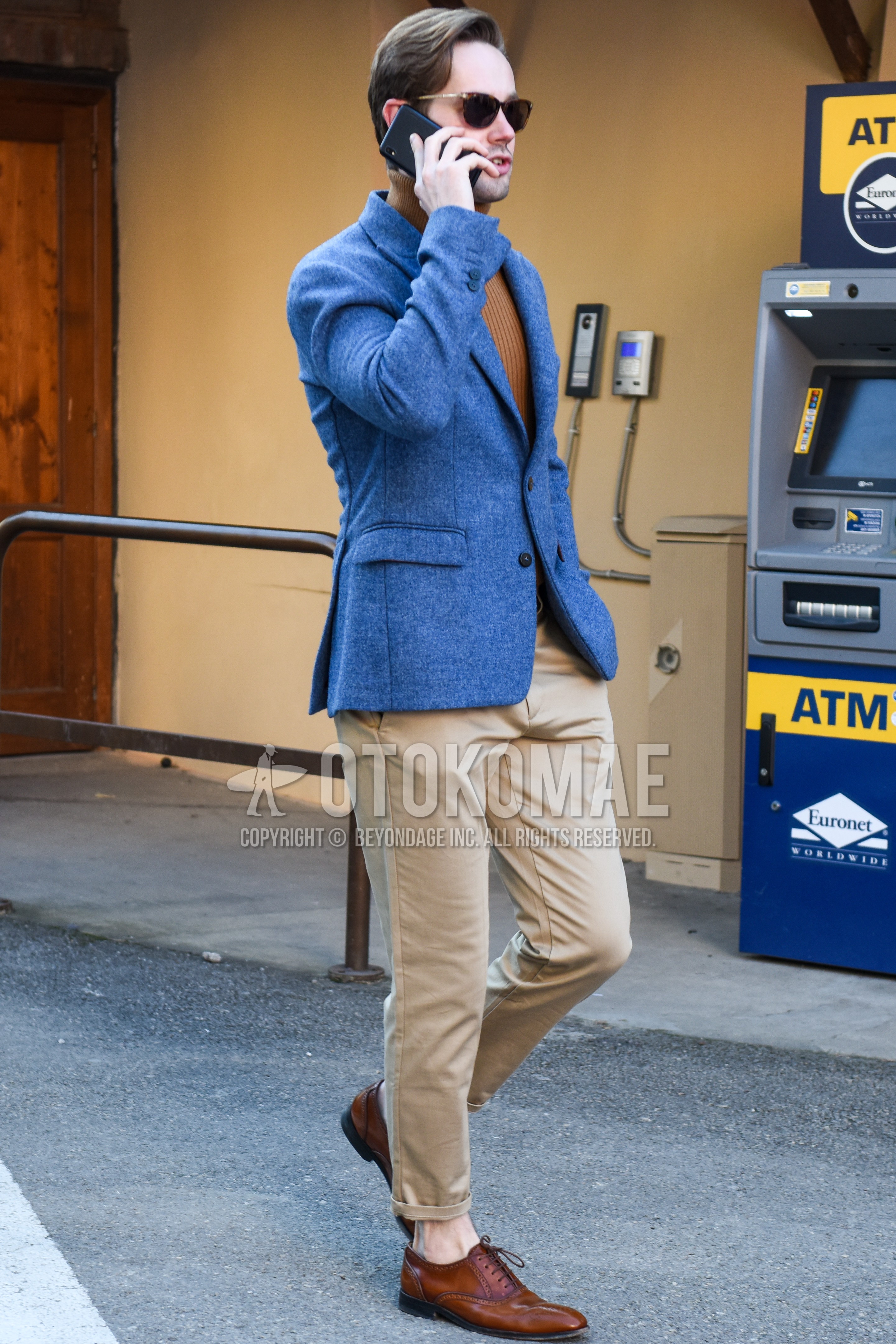 Men's spring autumn outfit with brown tortoiseshell sunglasses, gray plain tailored jacket, brown plain turtleneck knit, beige plain chinos, brown brogue shoes leather shoes.