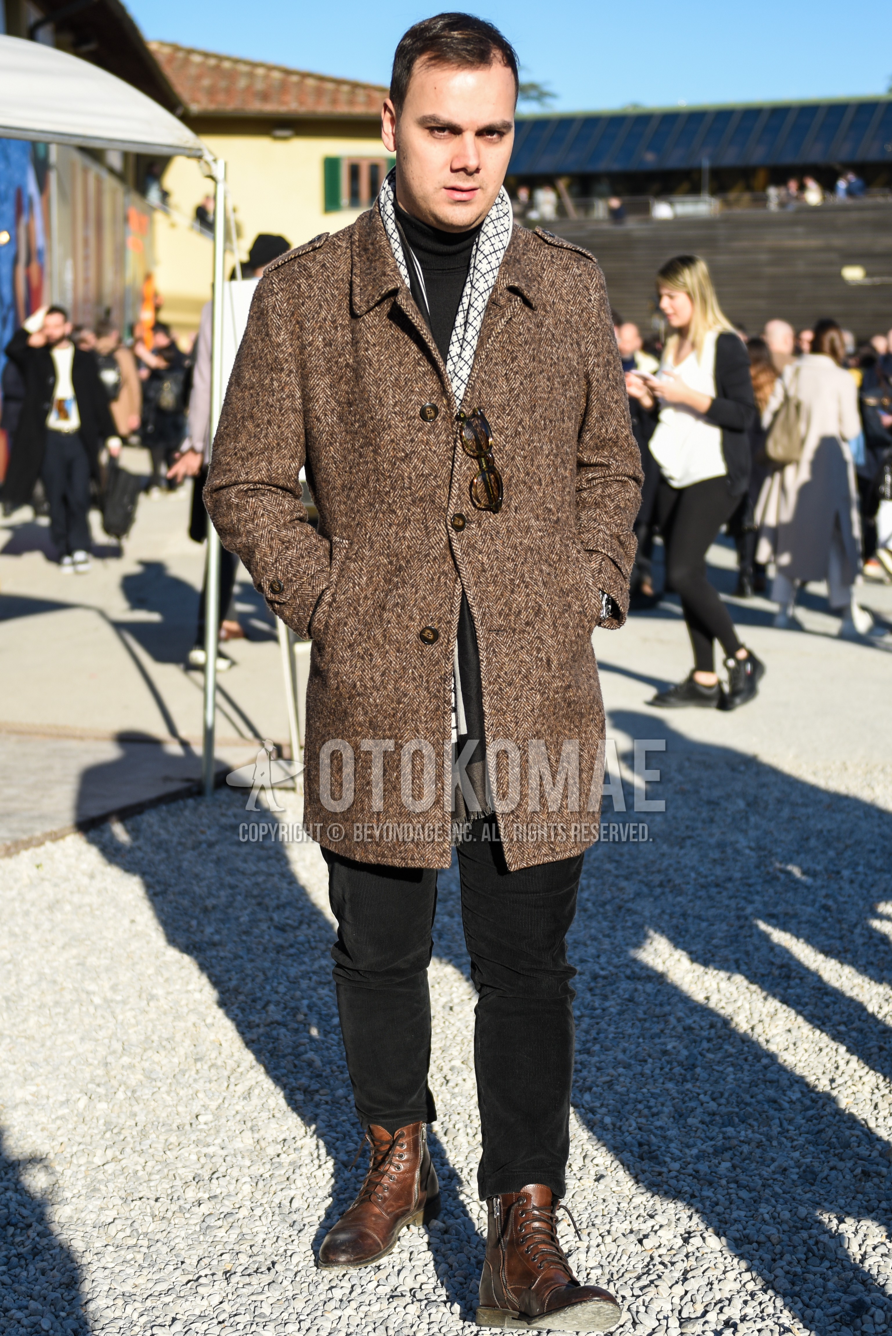 Men's autumn winter outfit with gray scarf scarf, brown herringbone stenkarrer coat, black plain turtleneck knit, black plain damaged jeans, brown work boots.